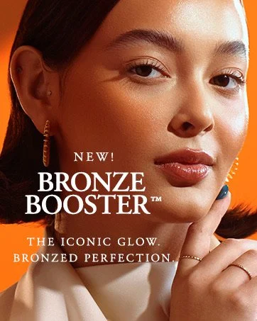 Close-up of a woman's face with subtle makeup, gold hoop earrings, and a ring, holding her finger near her face. Text overlay promoting Bronze Booster makeup product.