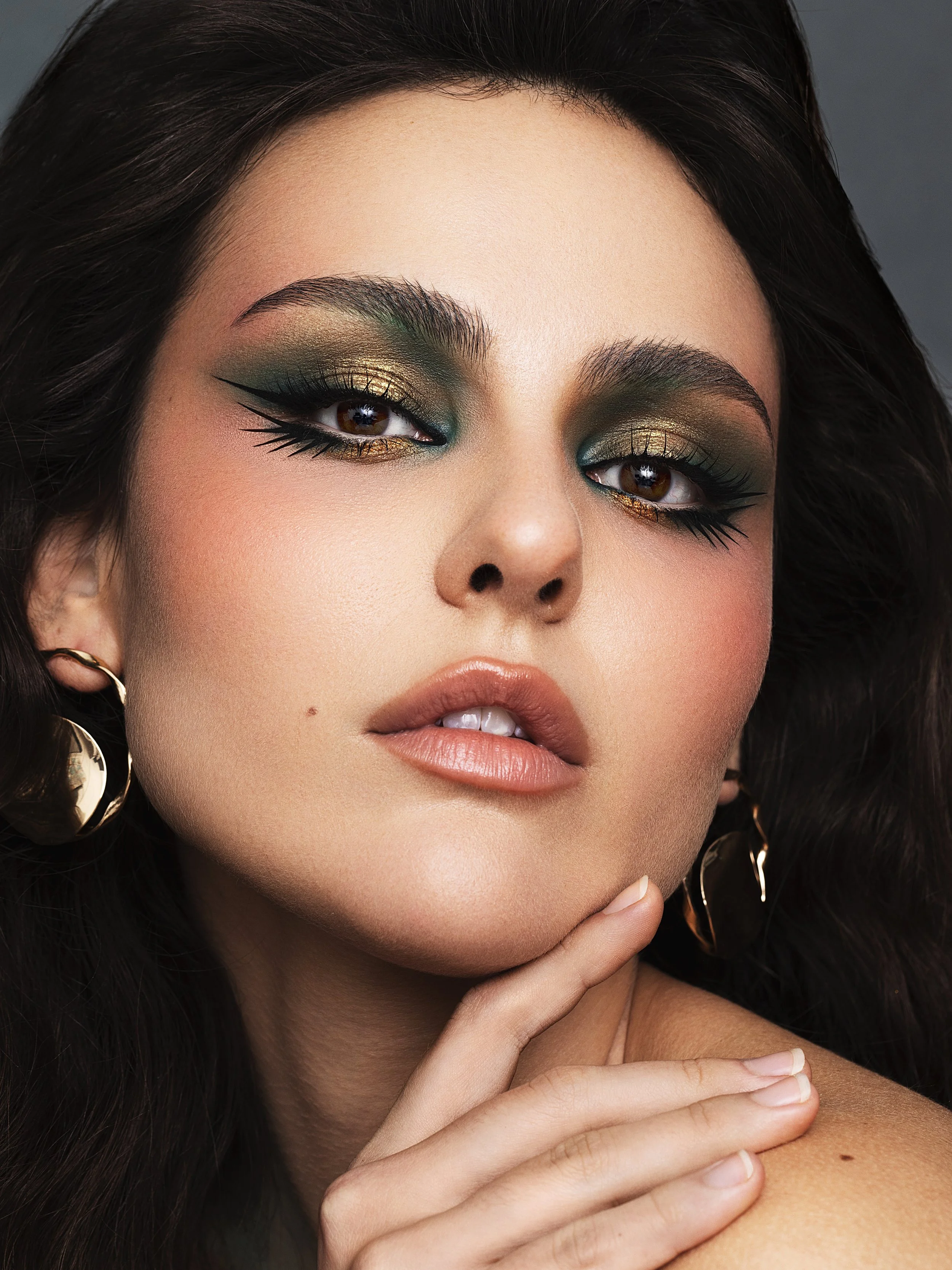 Close-up of a woman with glamorous makeup and gold earrings. Beauty Photographer Los Angeles.