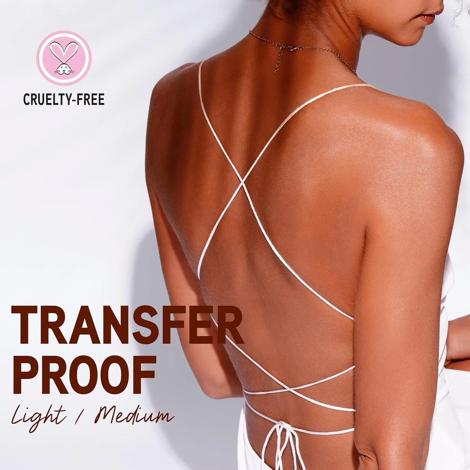 A woman with tanned skin wearing a white dress with thin crisscrossing straps on her back. The image promotes a cruelty-free, transfer-proof product in light and medium shades. Commercial Photographer Los Angeles.