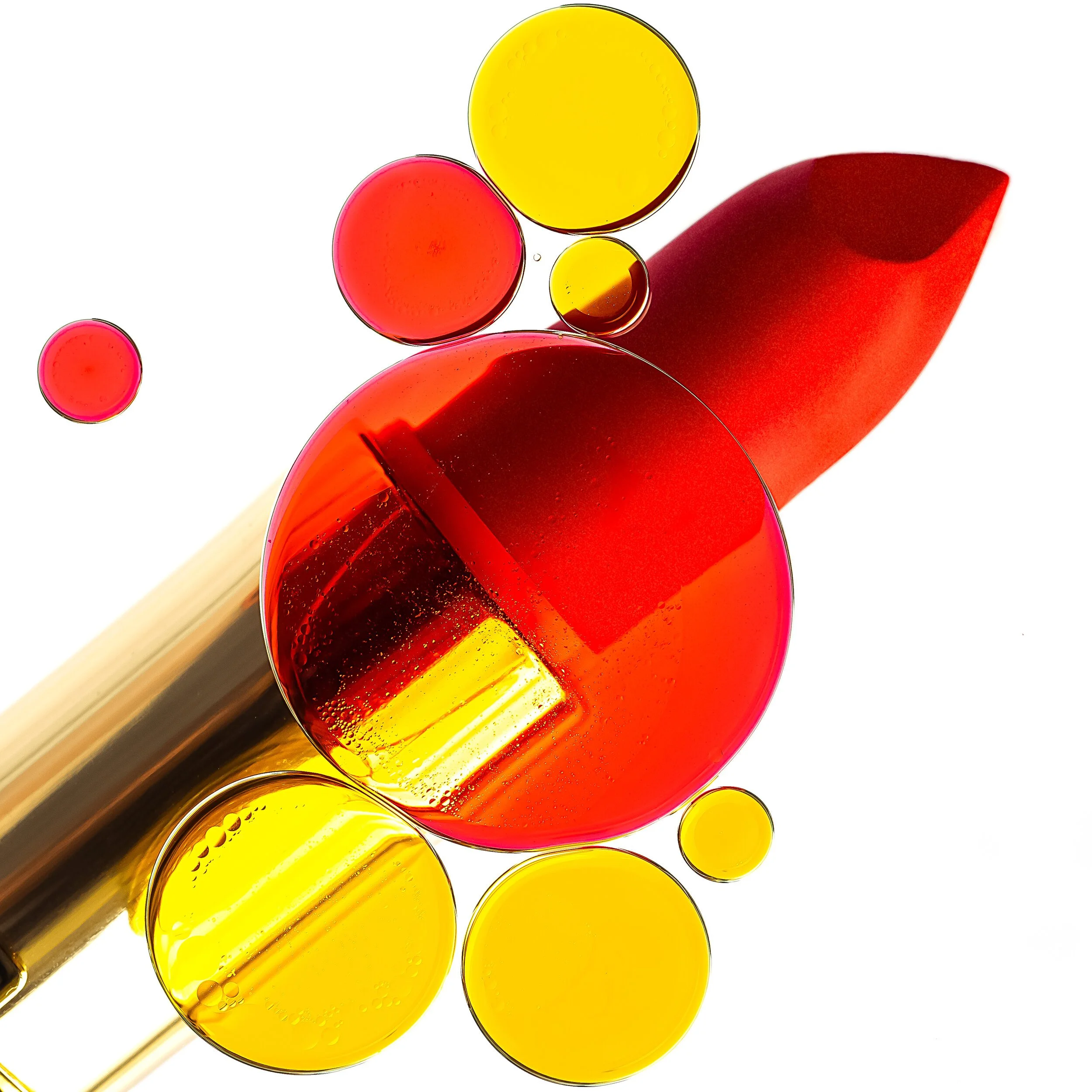 Colorful oil and water bubbles with a pipette, showing red and yellow liquids. Product photography Los Angeles.