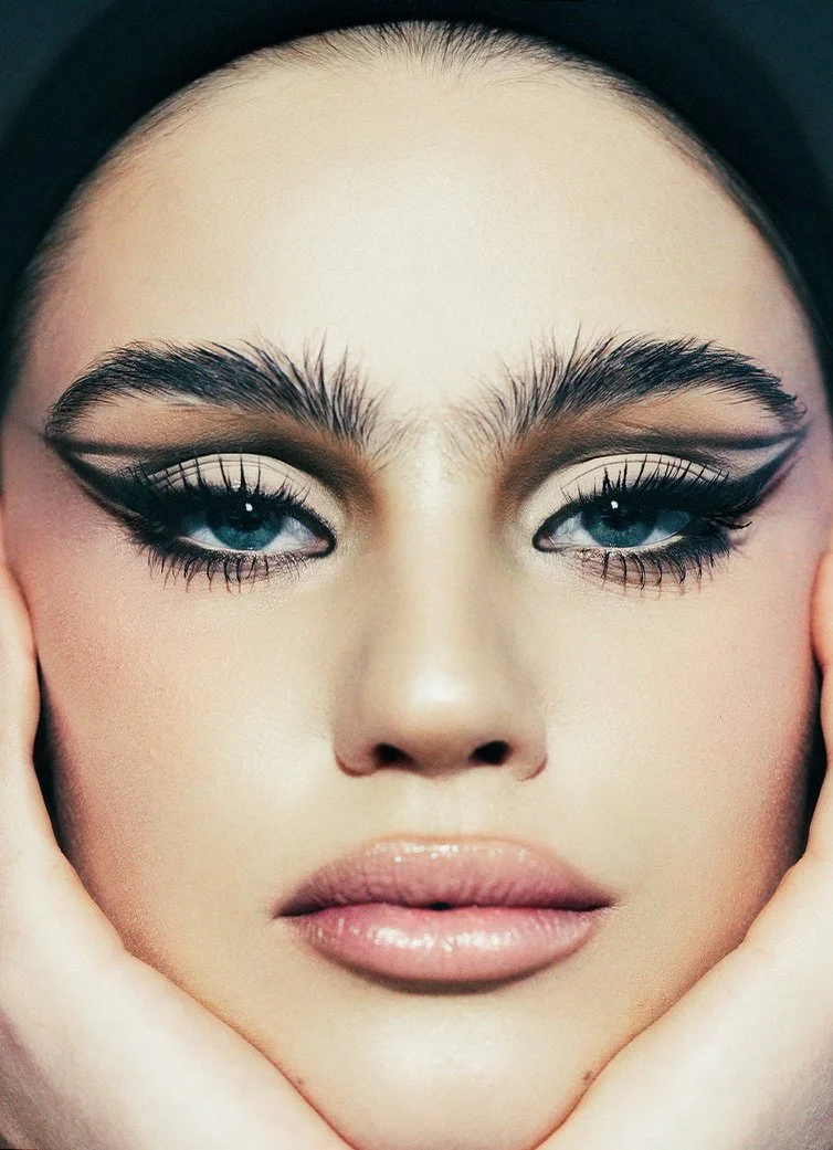 Close-up of a woman with striking makeup, including winged eyeliner, eyeshadow, full lips, and blue eyes. Beauty Photographer Los Angeles.