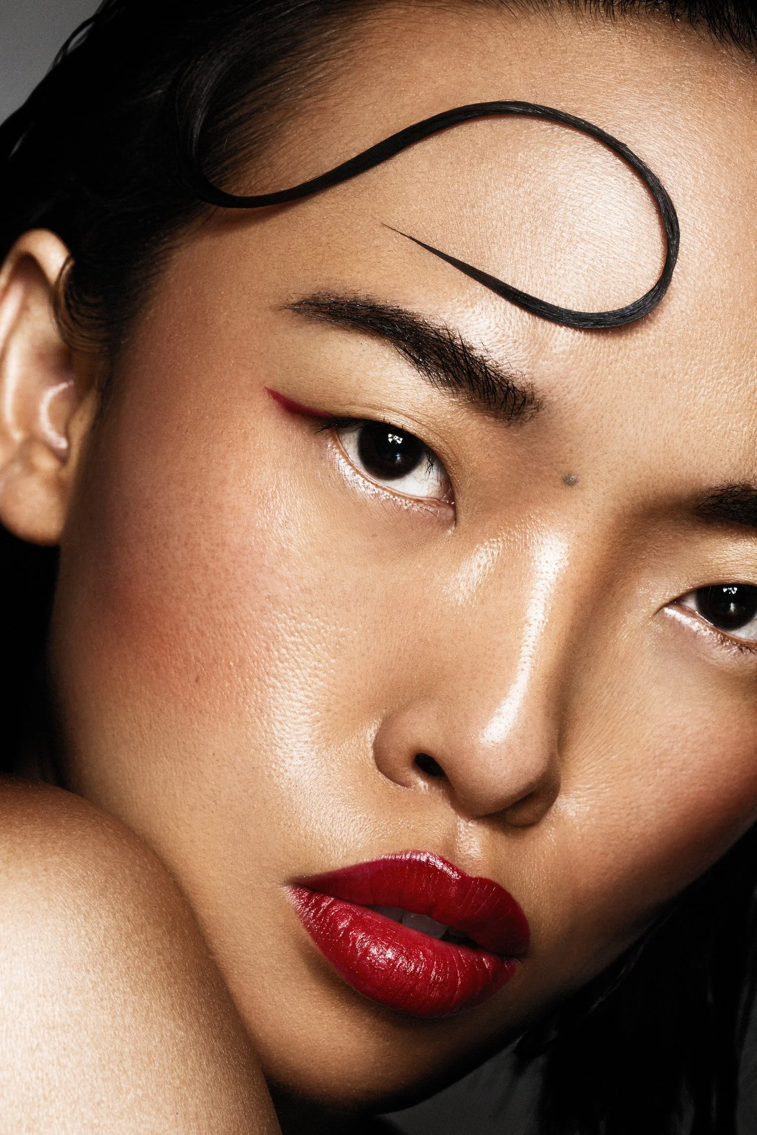 Close-up of a woman's face with styled hair, bold red lipstick, and makeup. Beauty Photographer Los Angeles.