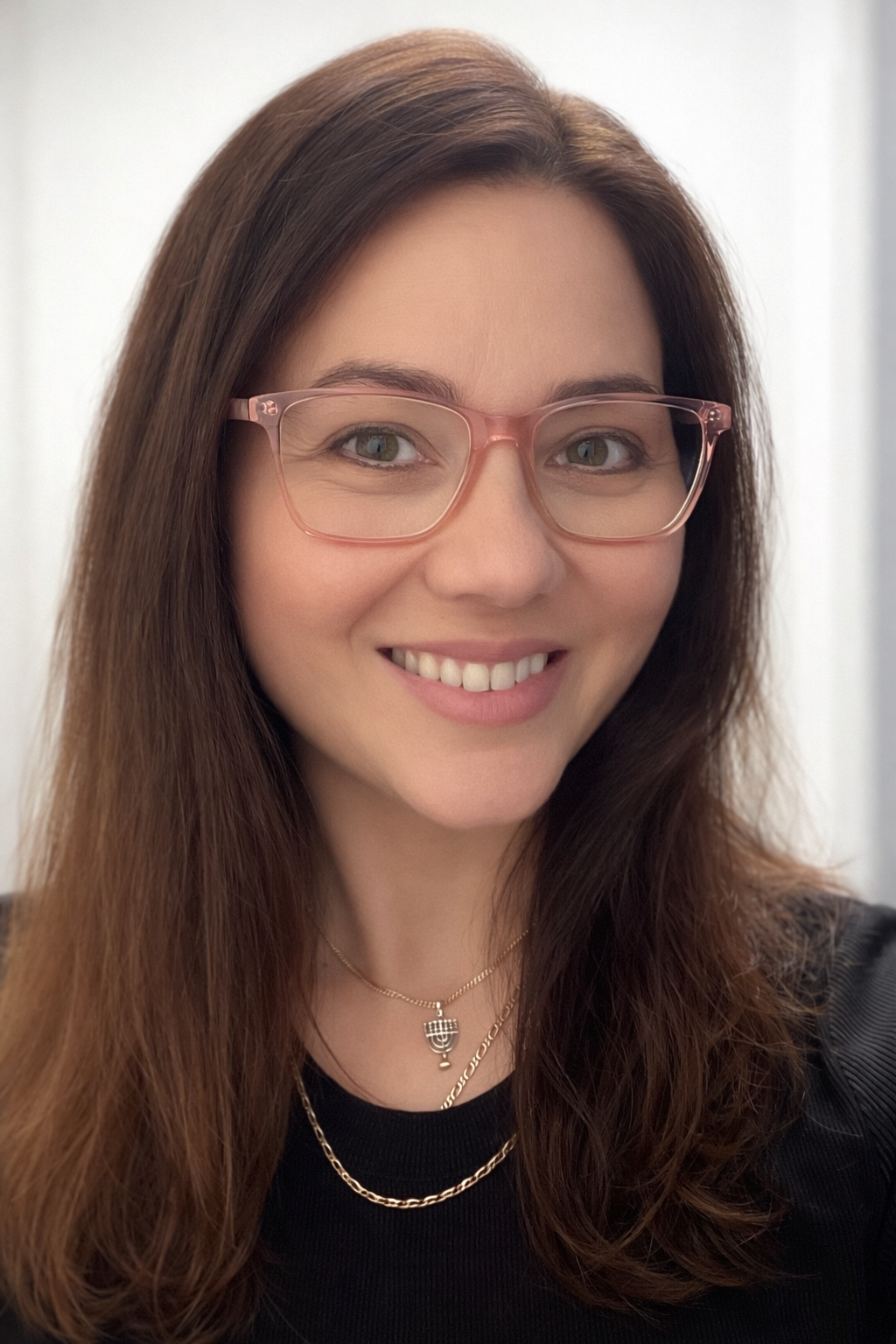 Young Woman with bright smile and long brown hair wearing stylish pink glasses