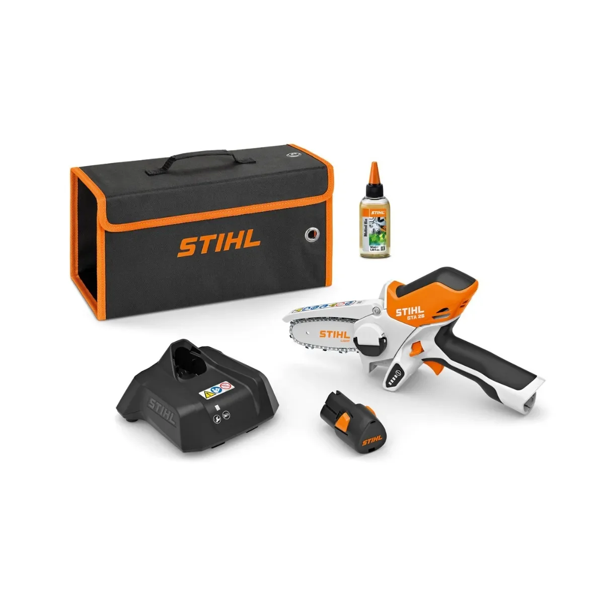 A cordless electric chainsaw, a black battery charger, a small battery pack, a bottle of chain oil, and an orange and black carrying case with the STIHL logo.