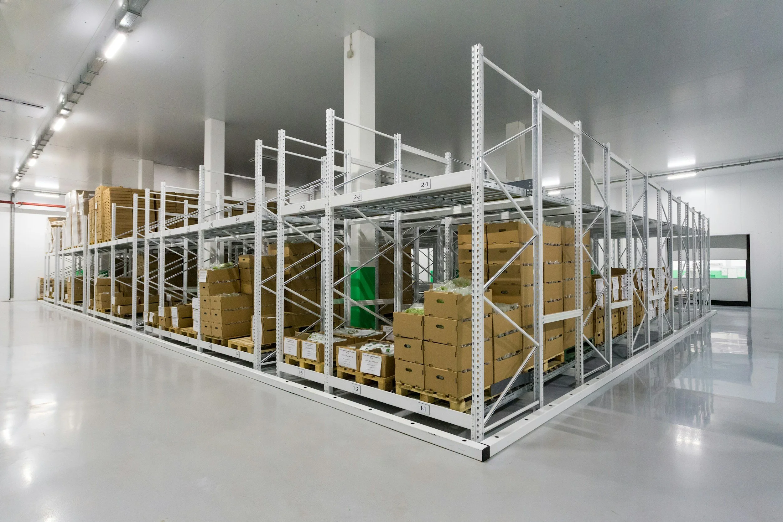 Empty warehouse with metal shelving units stocked with cardboard boxes.