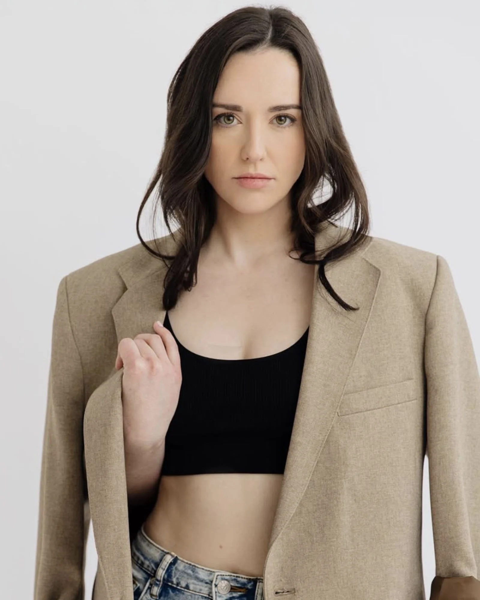 Woman with brunette hair wearing a sable overcoat and black top