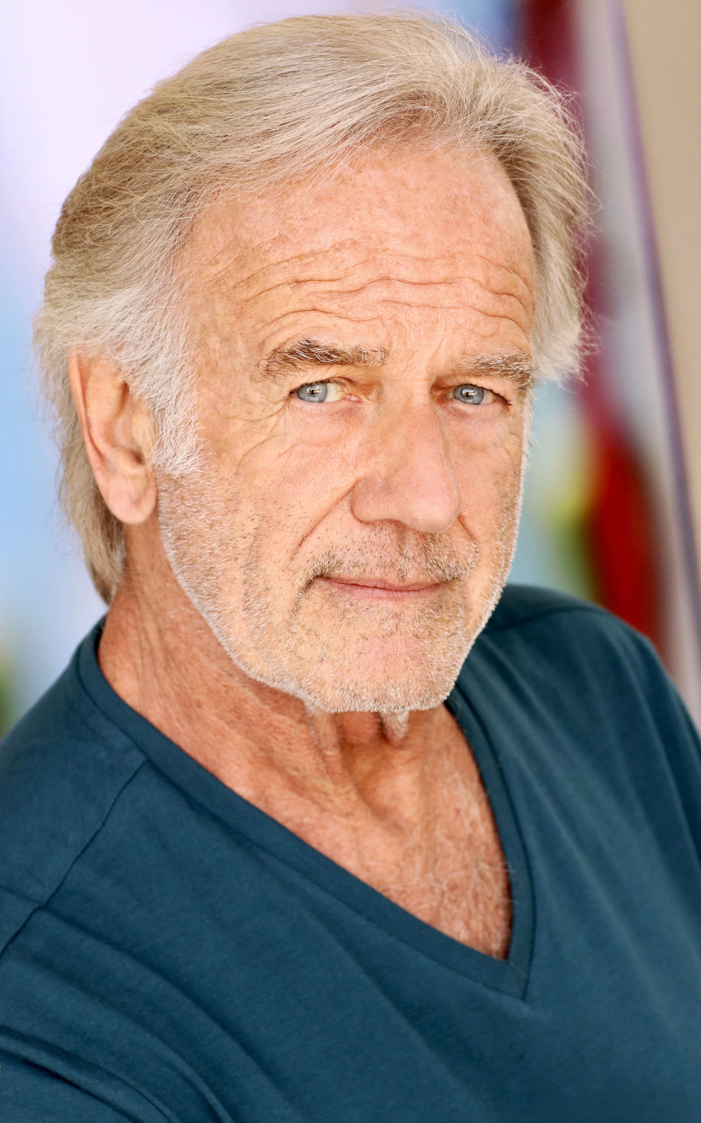 A handsome gray-haired man with a blue t-shirt
