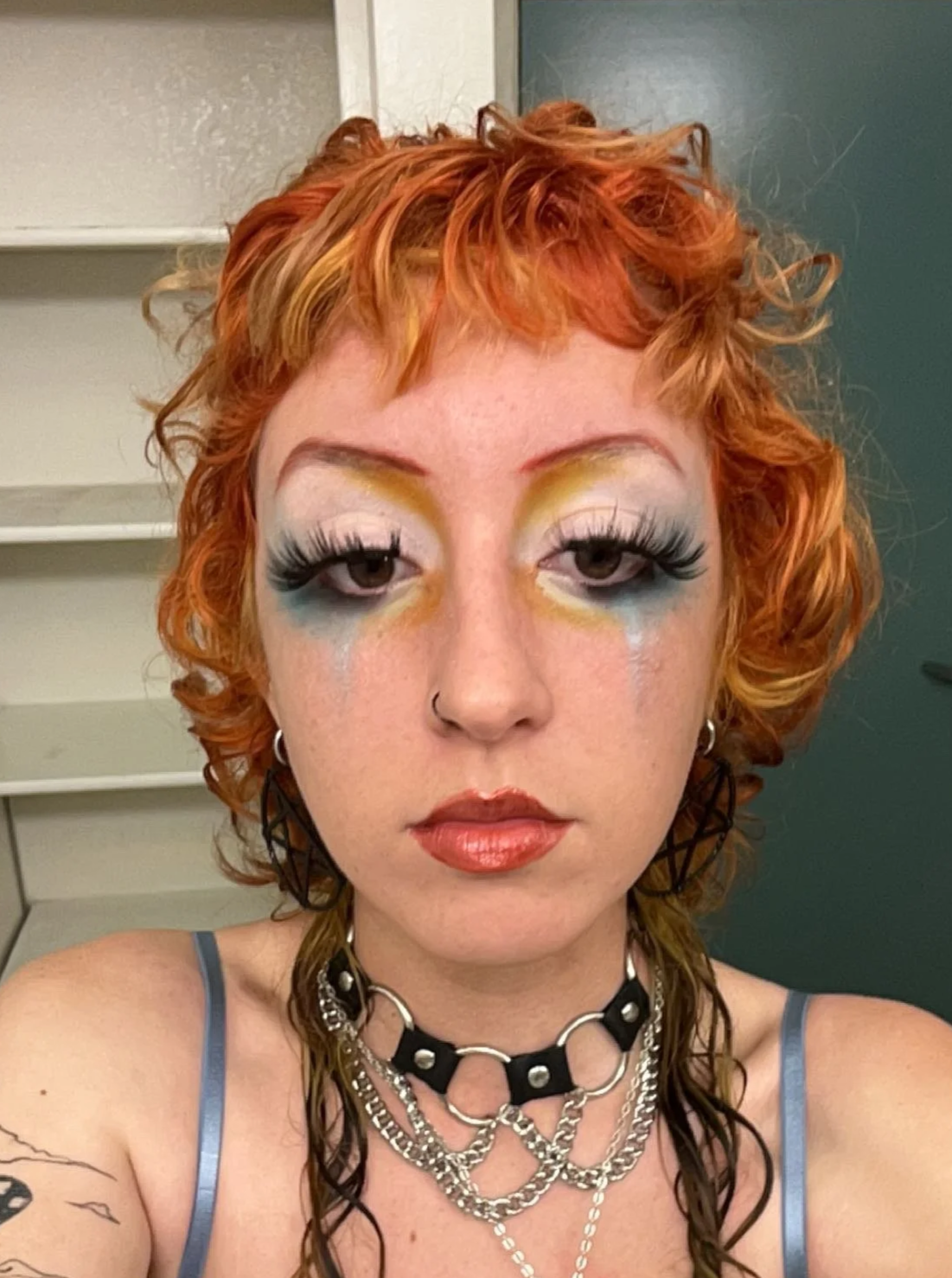 Blue, orange, and yellow blended eyeshadow and iridescent tear makeup