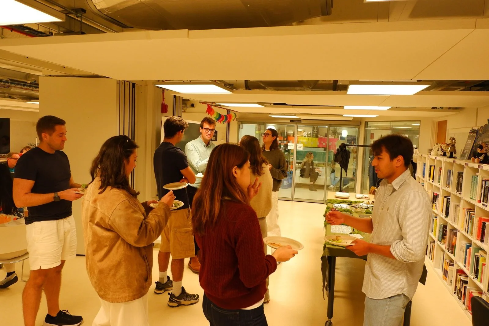 Colleagues queuing with plates at an office buffet lunch