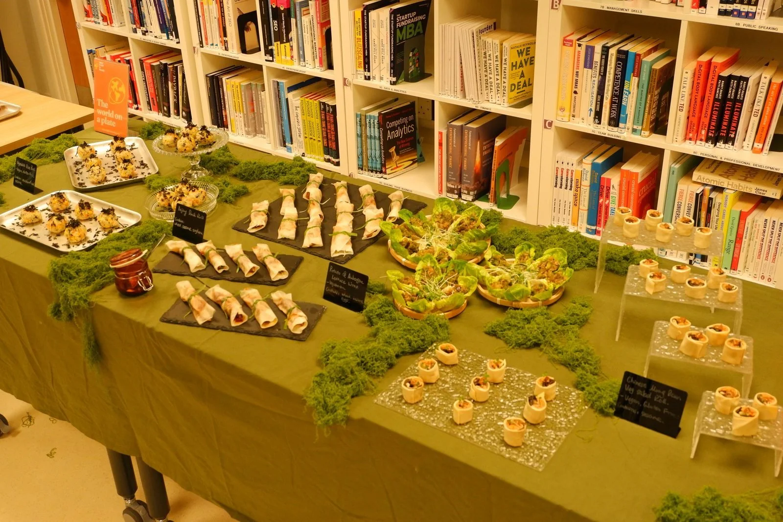 A buffet table of labelled canapes and small dishes at an office event
