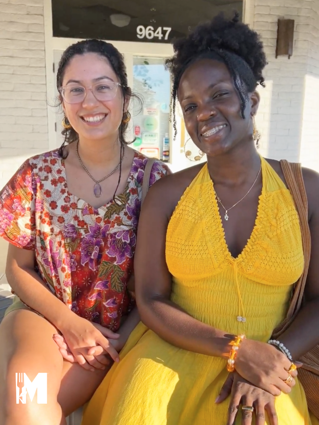 two ladies posing for the camera in colorful attire