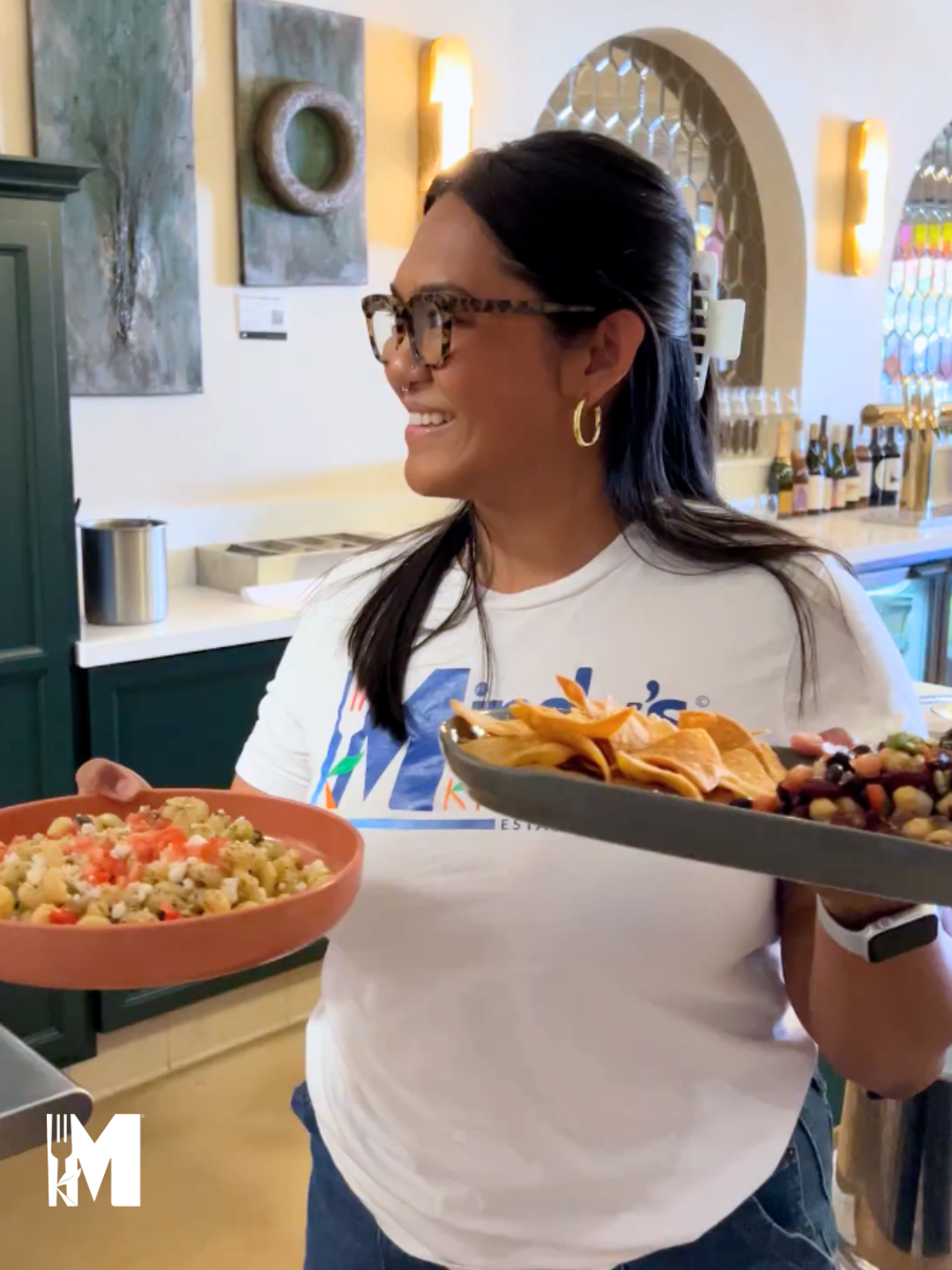 Siena holding two plates of salad looking to the left smiling