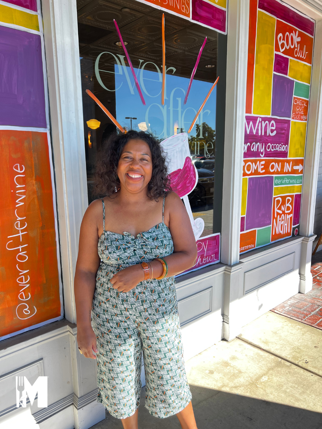 a woman smiling in front a colorful window