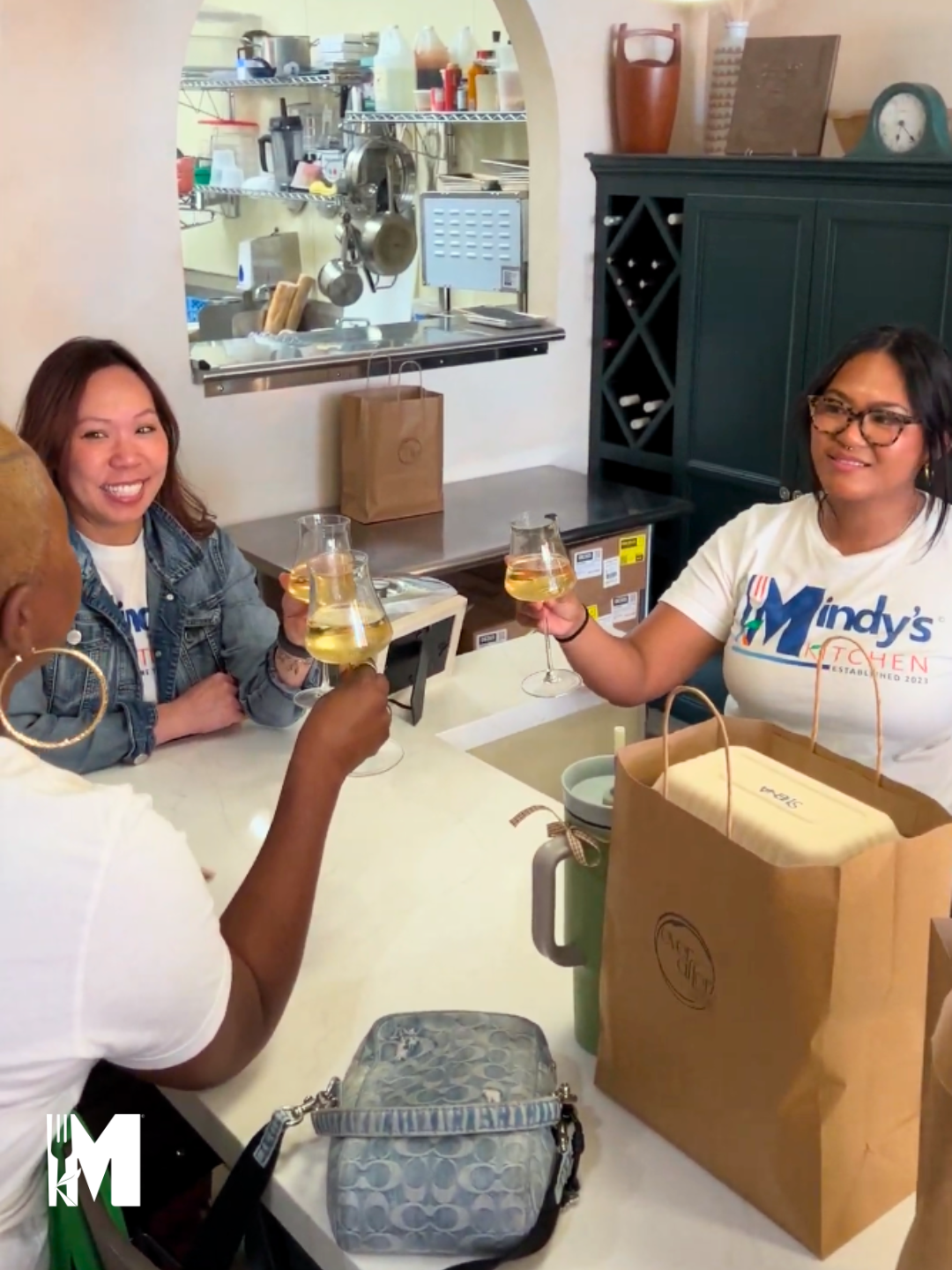 Three ladies holding their wine glasses in a "cheers" position