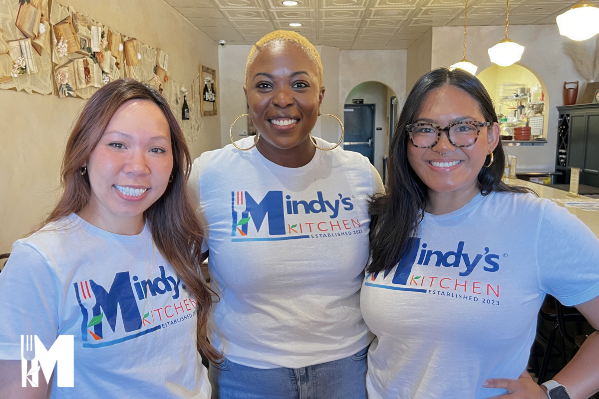 Three ladies smiling, standing side to side.