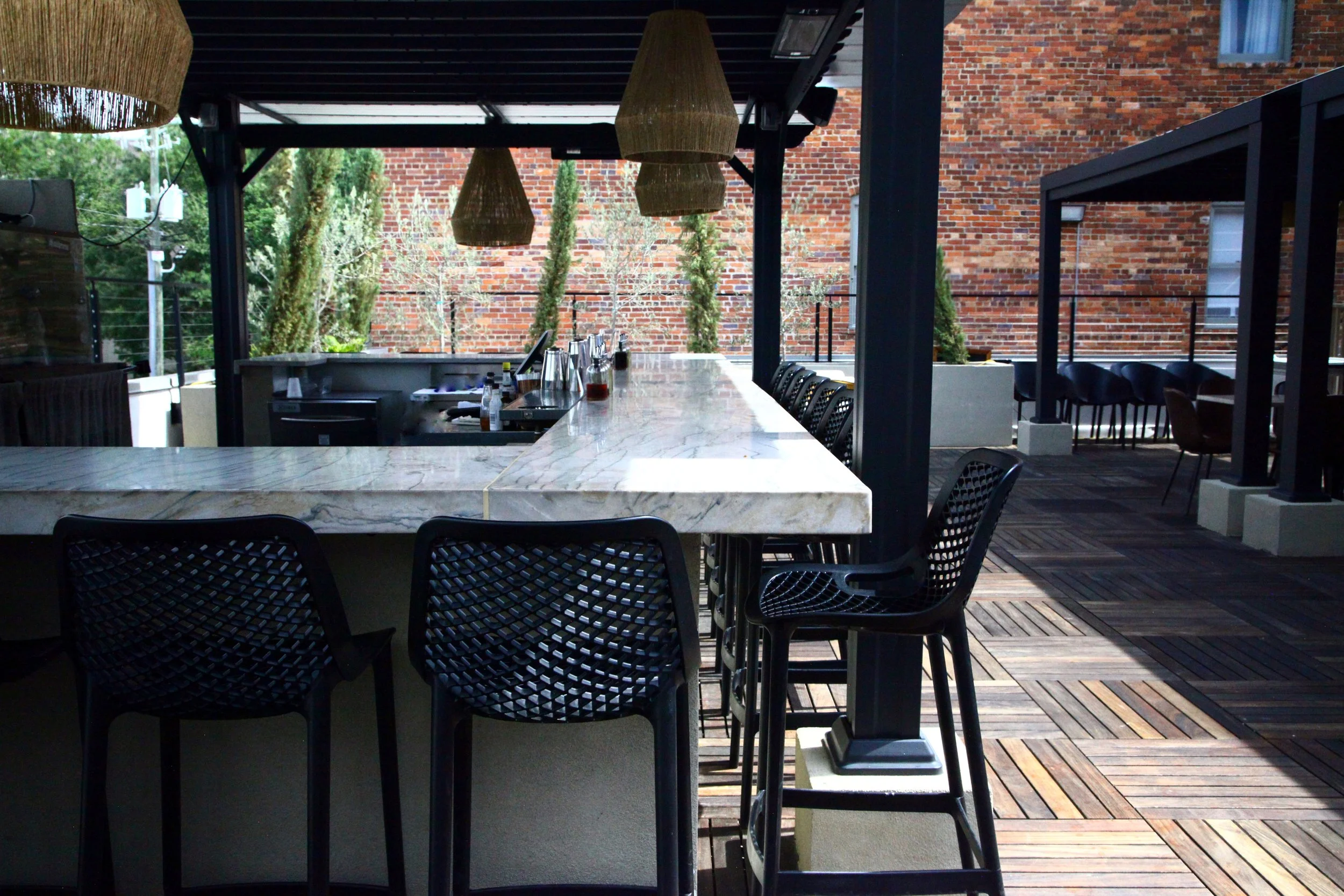 Vici Rooftop's outdoor marble bar and open air dining space overlooking historic Savannah.