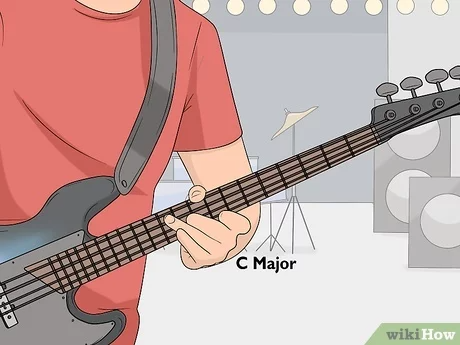 A man playing a bass guitar, focusing on his hands and the instrument, showcasing his technique and passion for music.
