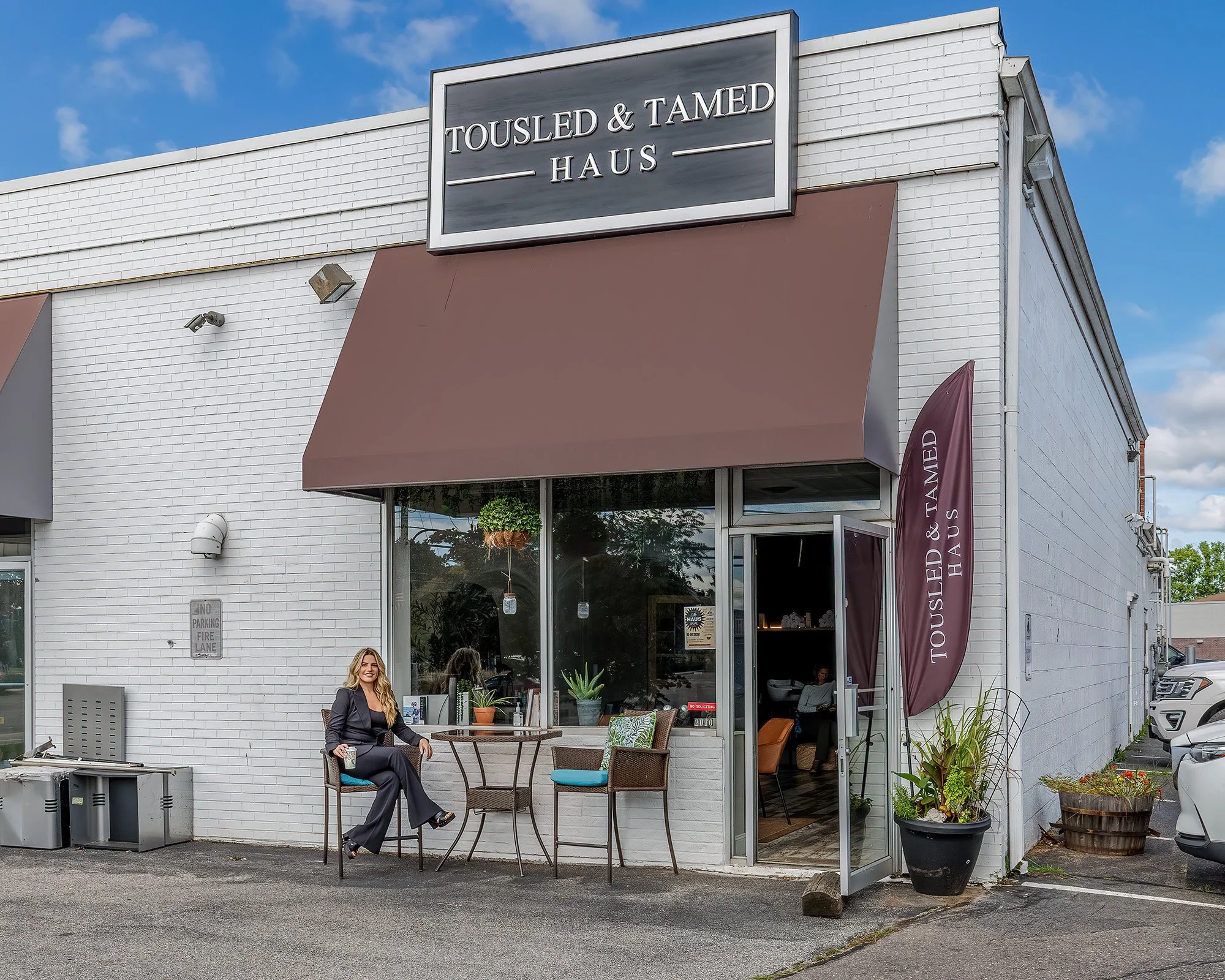 Business owner sitting in front of hair salon
