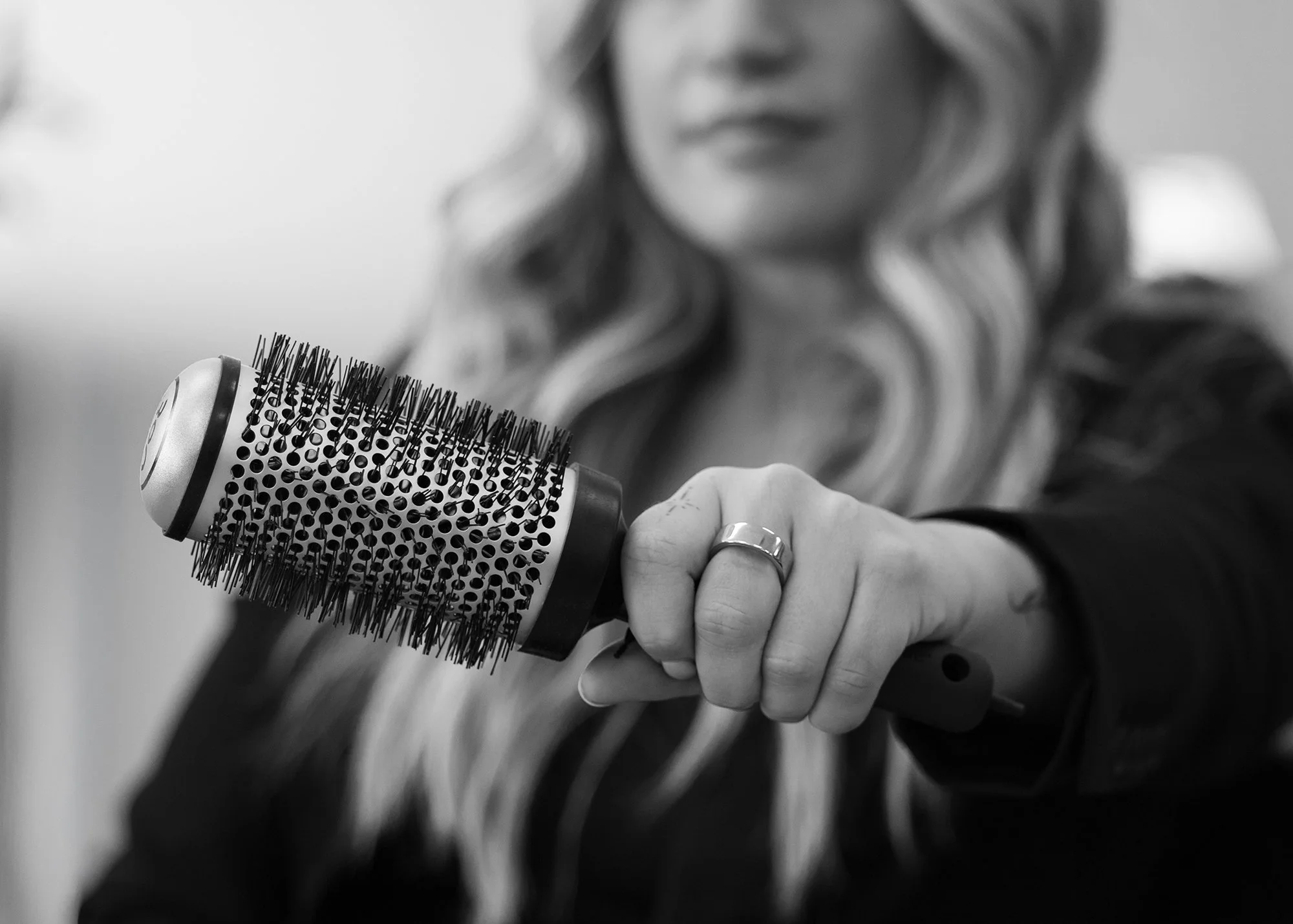 Black and white hair stylist holding a brush photograph