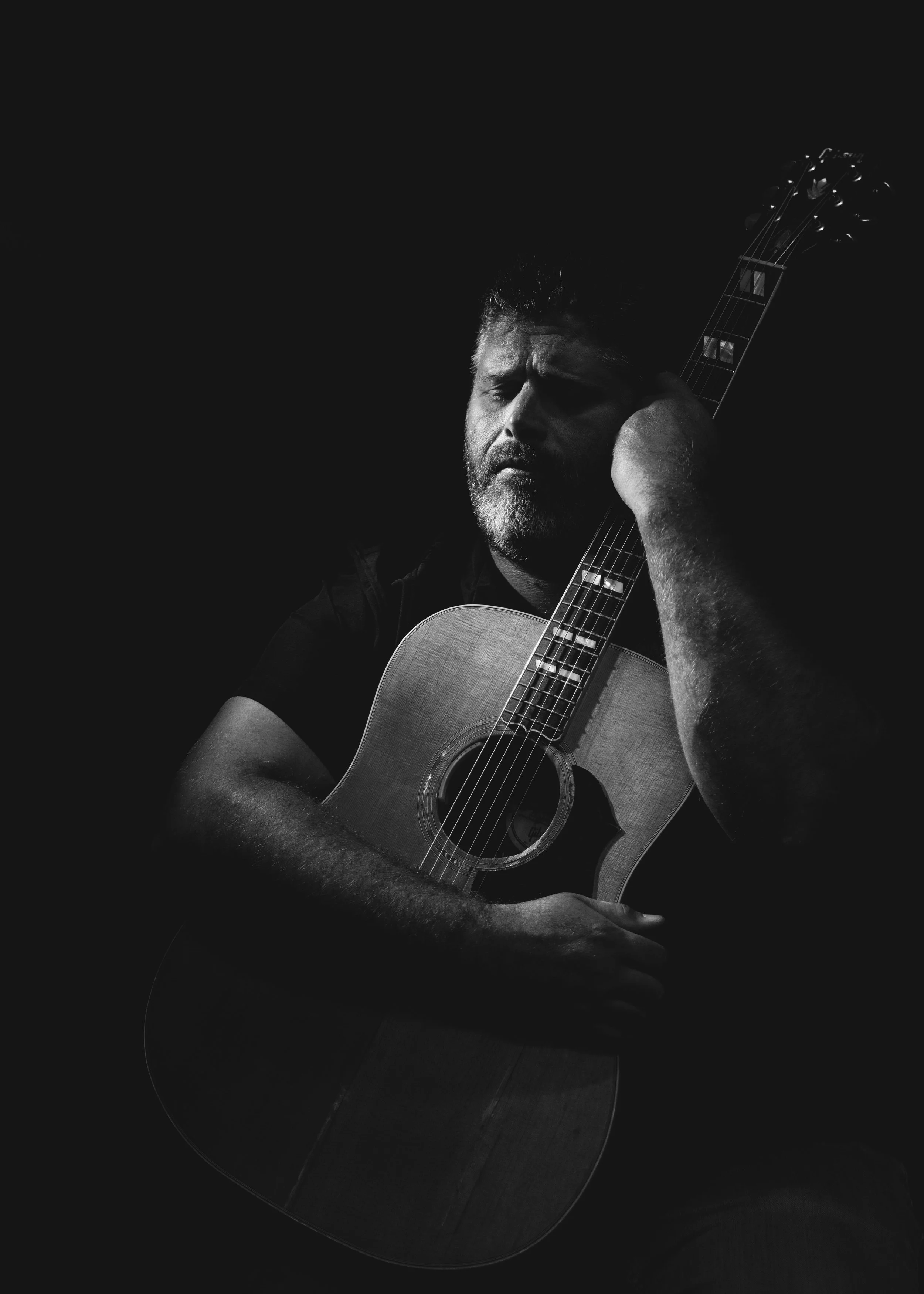 Musician hugging guitar black and white photography