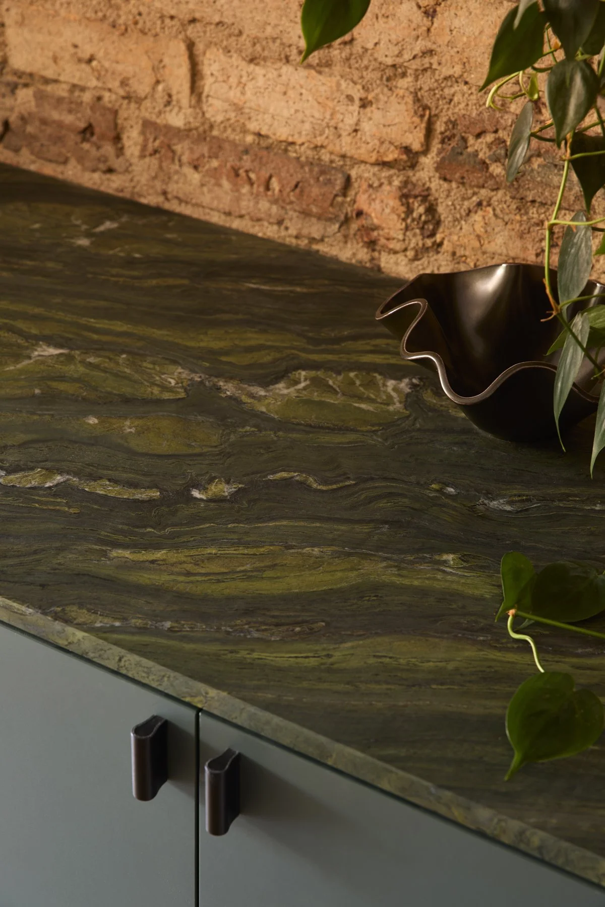 Green stone console top detail with red brick wall behind