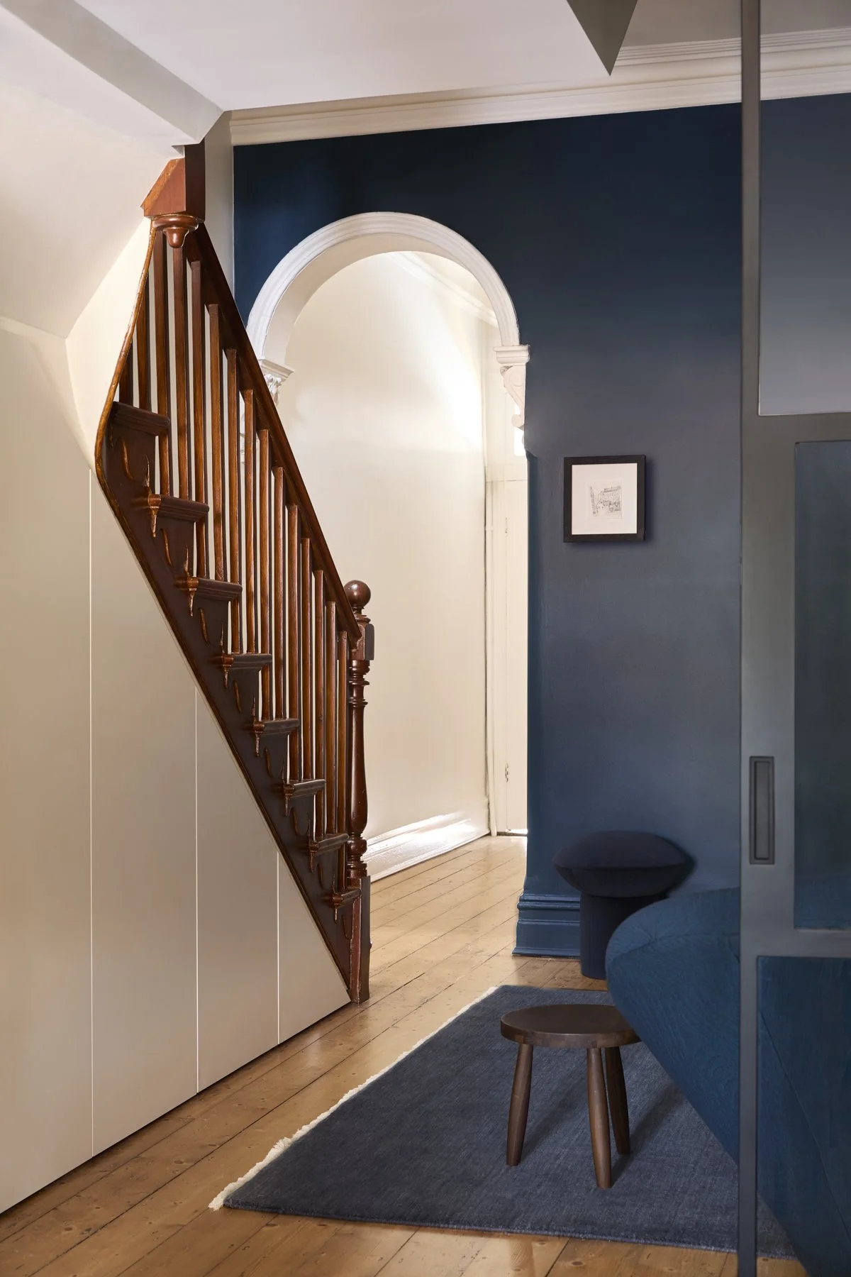 Blue living room with Victorian heritage staircase. Under stair storage