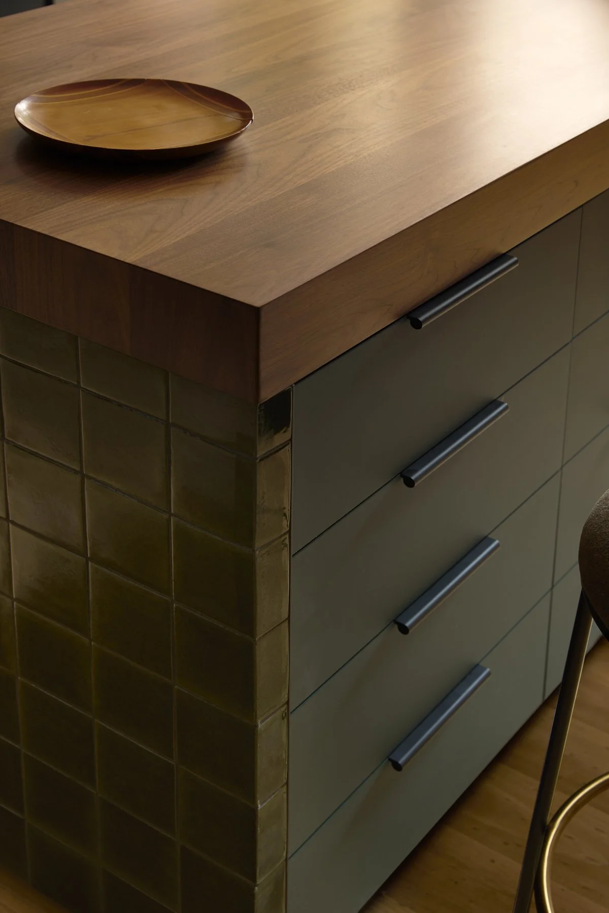 Kitchen island detail. Island in walnut timber benchtop with handmade green tiles
