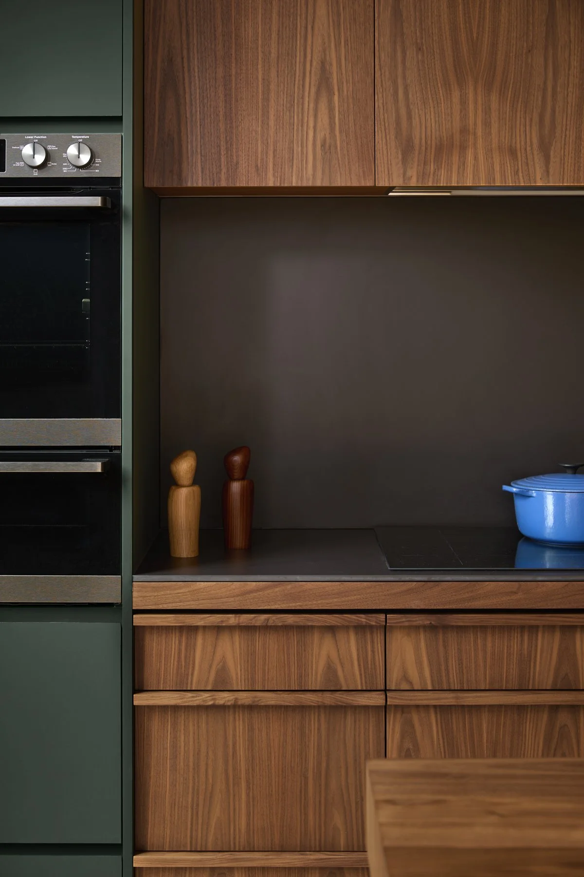 Kitchen oven stack with kitchen backbench in black porcelain. walnut timber joinery with custom walnut door pulls