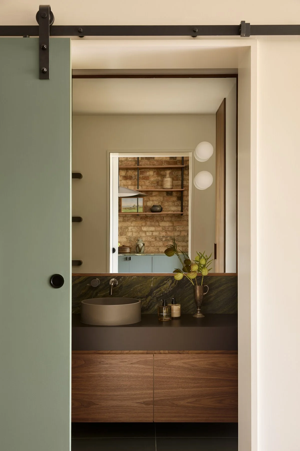 Bathroom vanity view through green barn doordoor