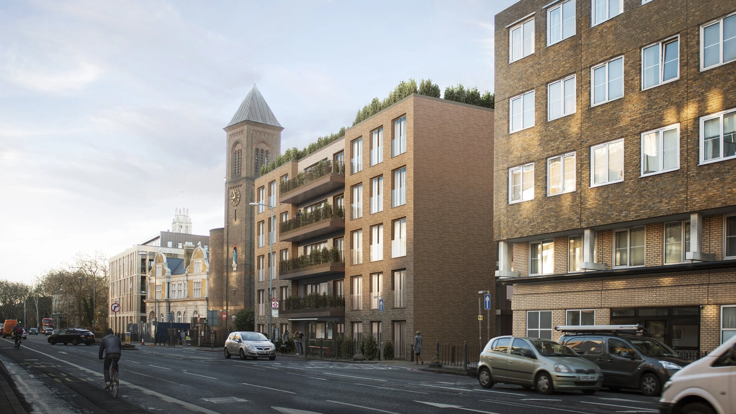 City street with modern brick apartment buildings, cars parked along the curb, a pedestrian, a cyclist, and a church steeple in the background during daytime.