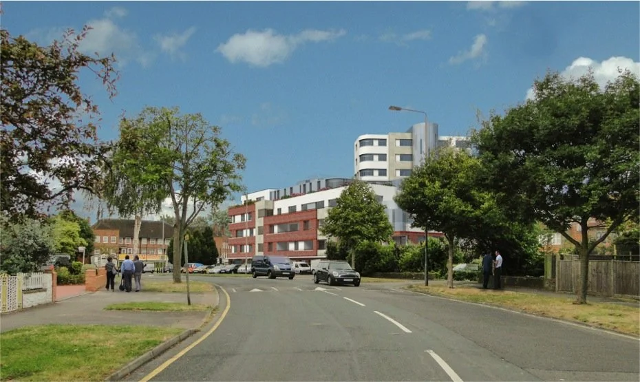 Residential street with trees, parked cars, and a group of people walking on the sidewalk near modern multi-story buildings under a partly cloudy sky.