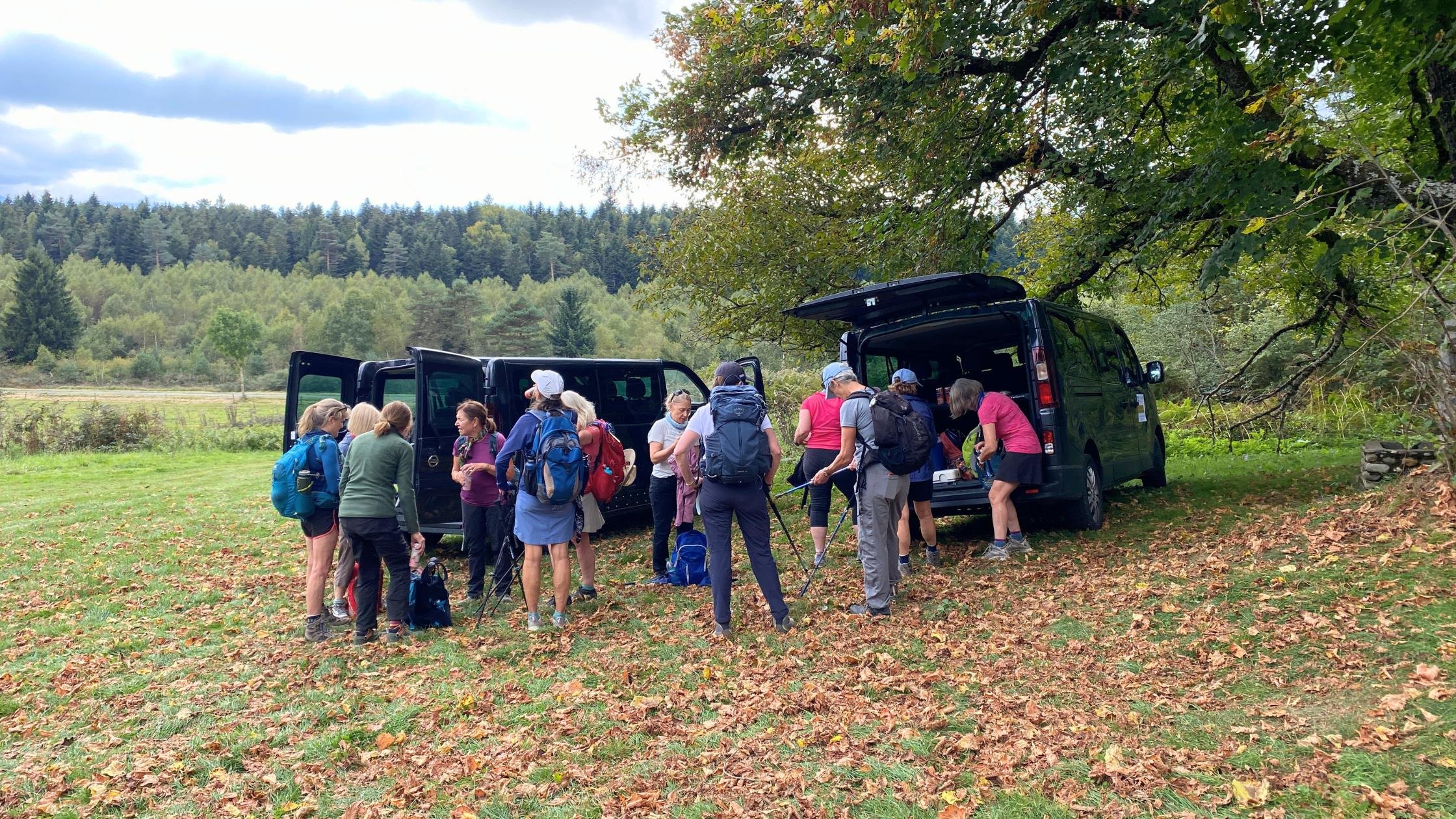 Women hikers putting their polls and backpacks into vans.