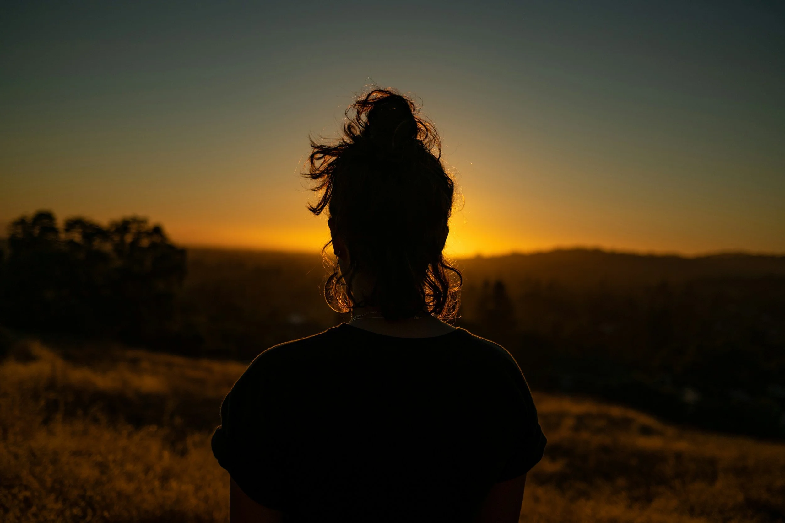 a woman reflecting on self awareness duirng a sunset