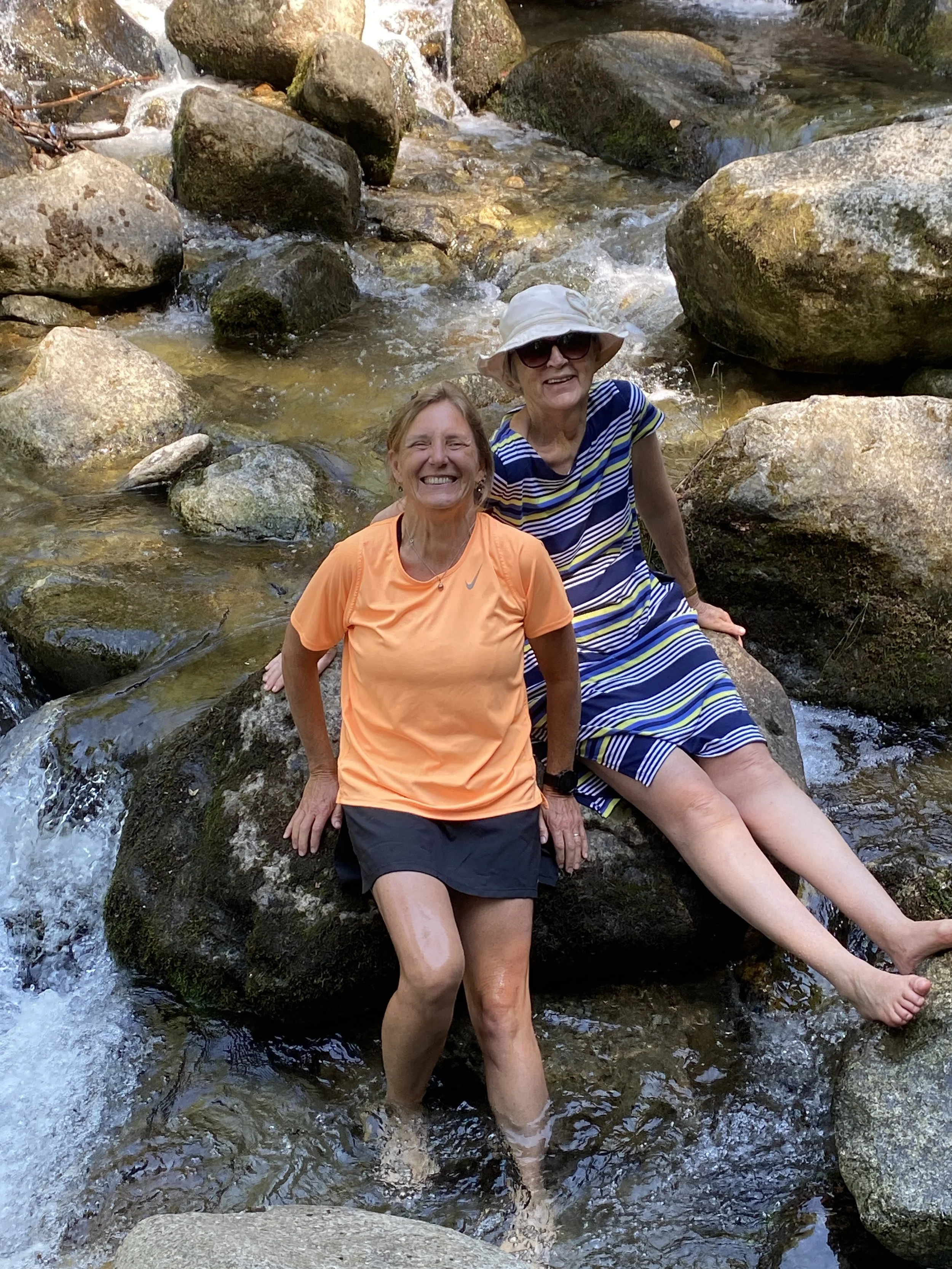 two women dipping their legs at gorges de galamus