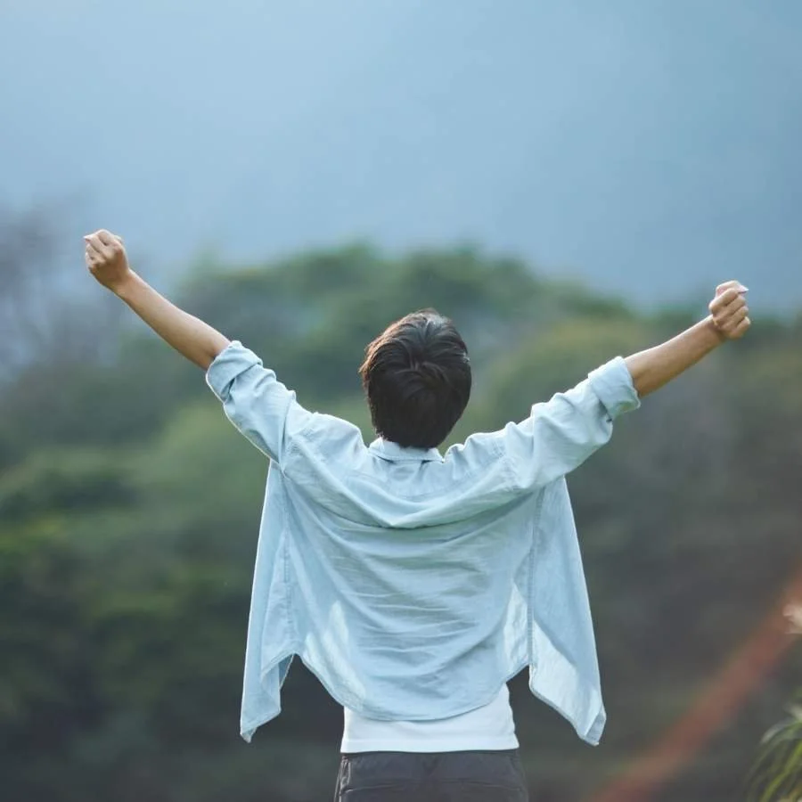 Man standing with his arms in the air feeling empowered.