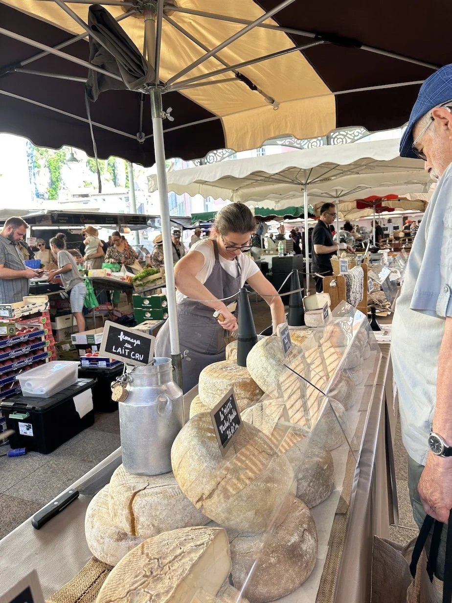 Woman selling locally made cheese in France in a local market