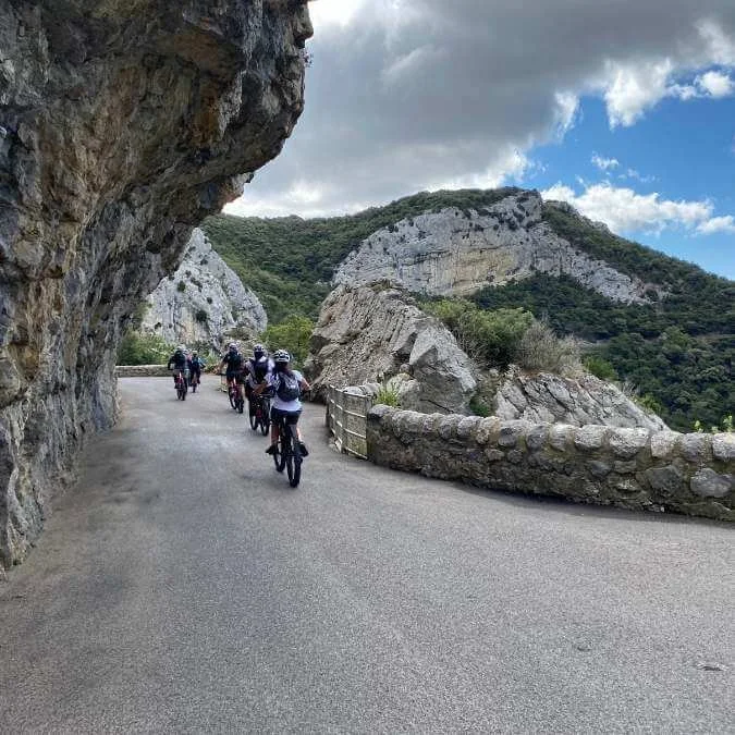 Cyclists riding through a rocky gorge during a biking and cultural tour in France