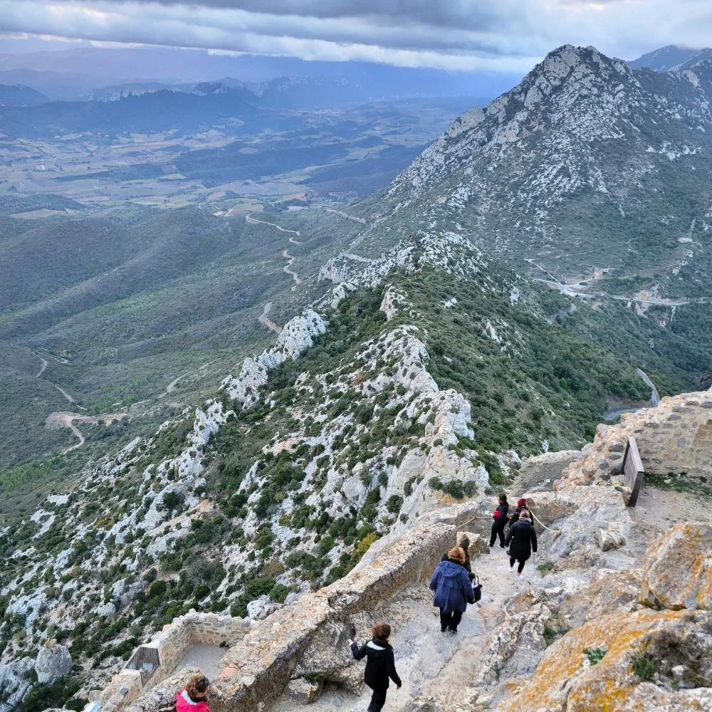 Travellers walking along a rocky mountain path during a hiking tour in France