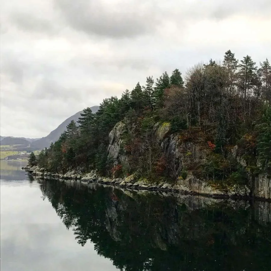 Image of an island in the middle of a dark Norwegian lake.
