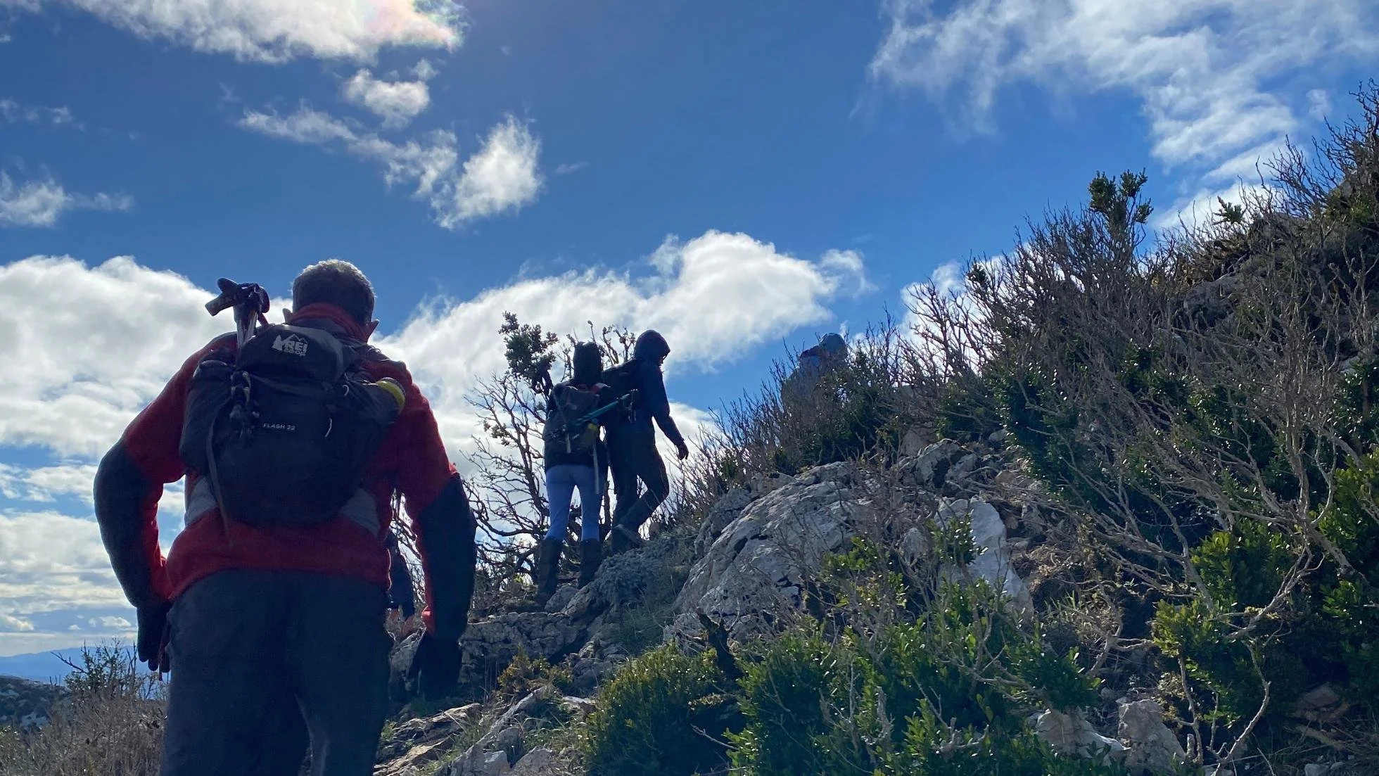Hikers walking up a steep trail to the summit.