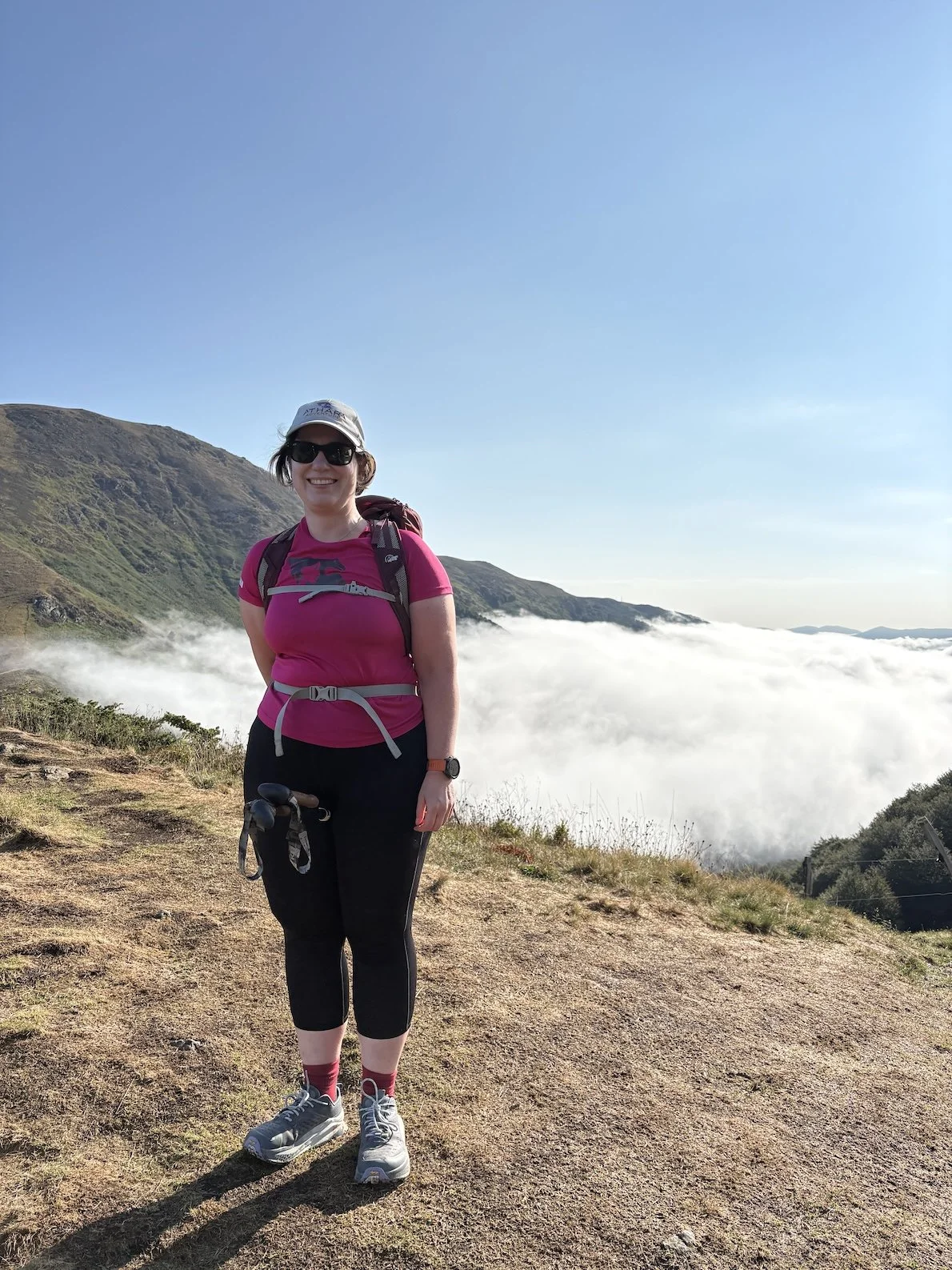 Anna is hiking above the clouds in the mountains in France