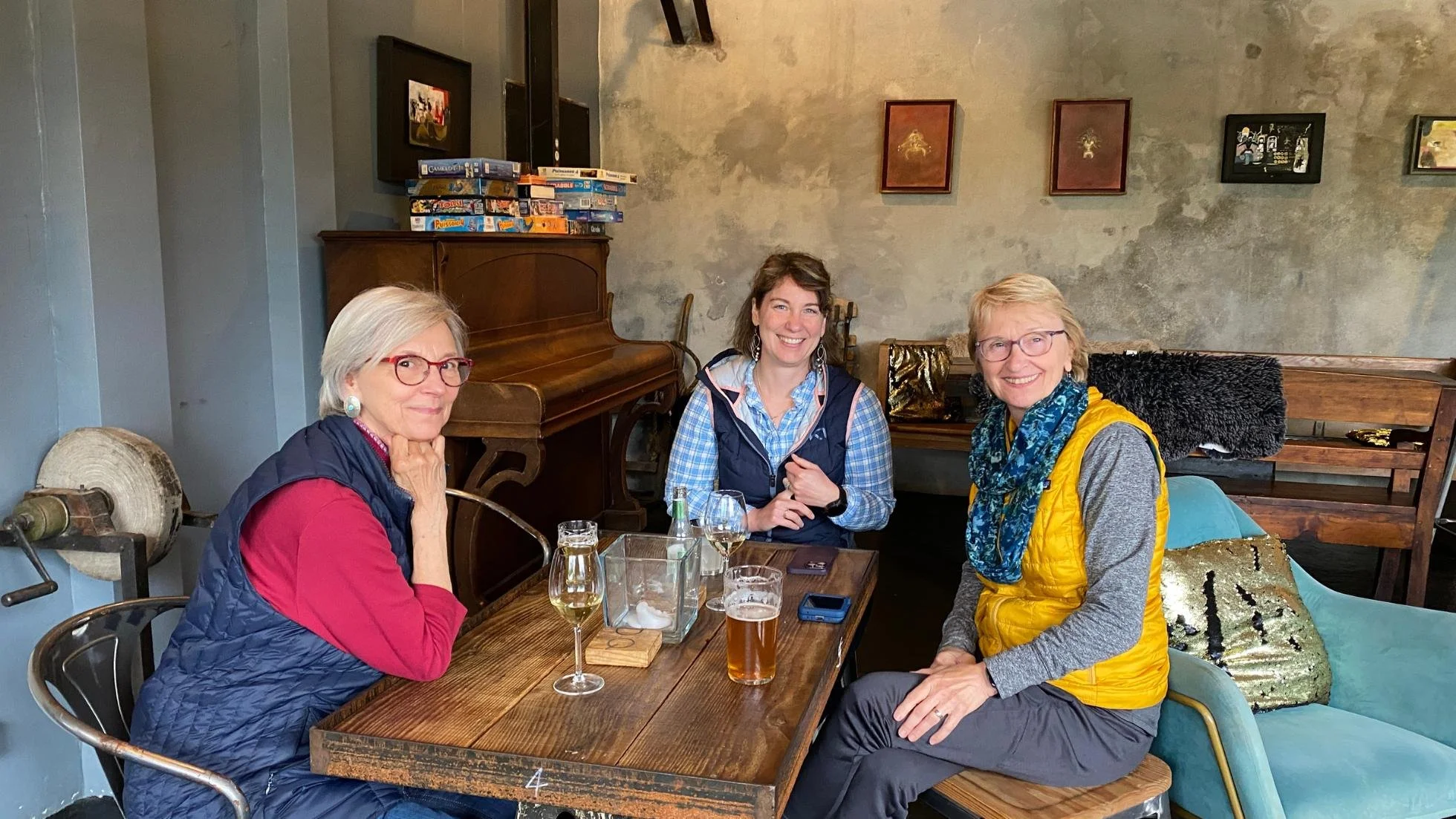 Three women of different generations sitting around a table in a bar.