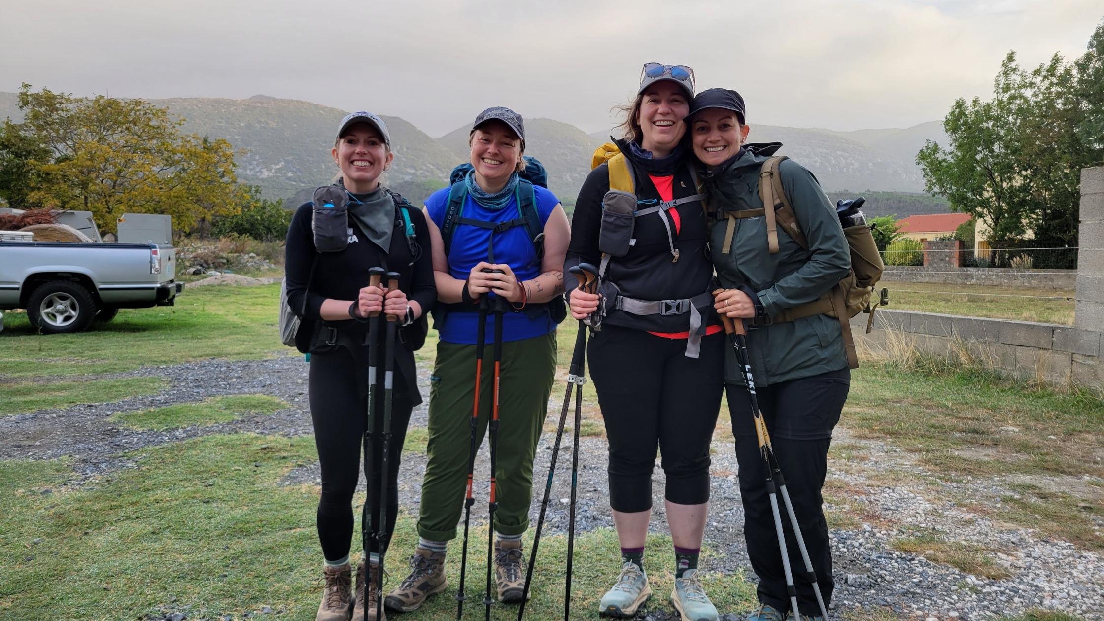 four women posing for a photo with hiking poles while Walking the Sentier Cathare