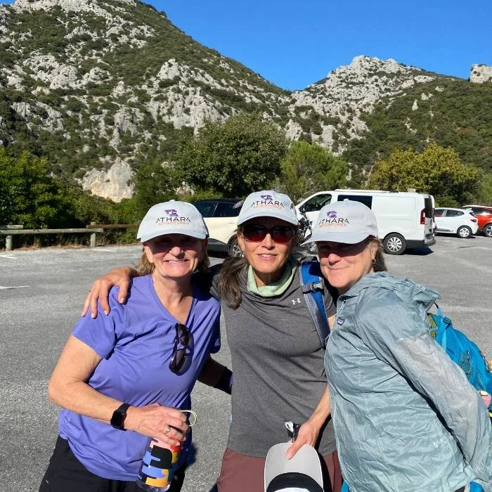 Three middle aged women wearing Athara Adventures hats and smiling.