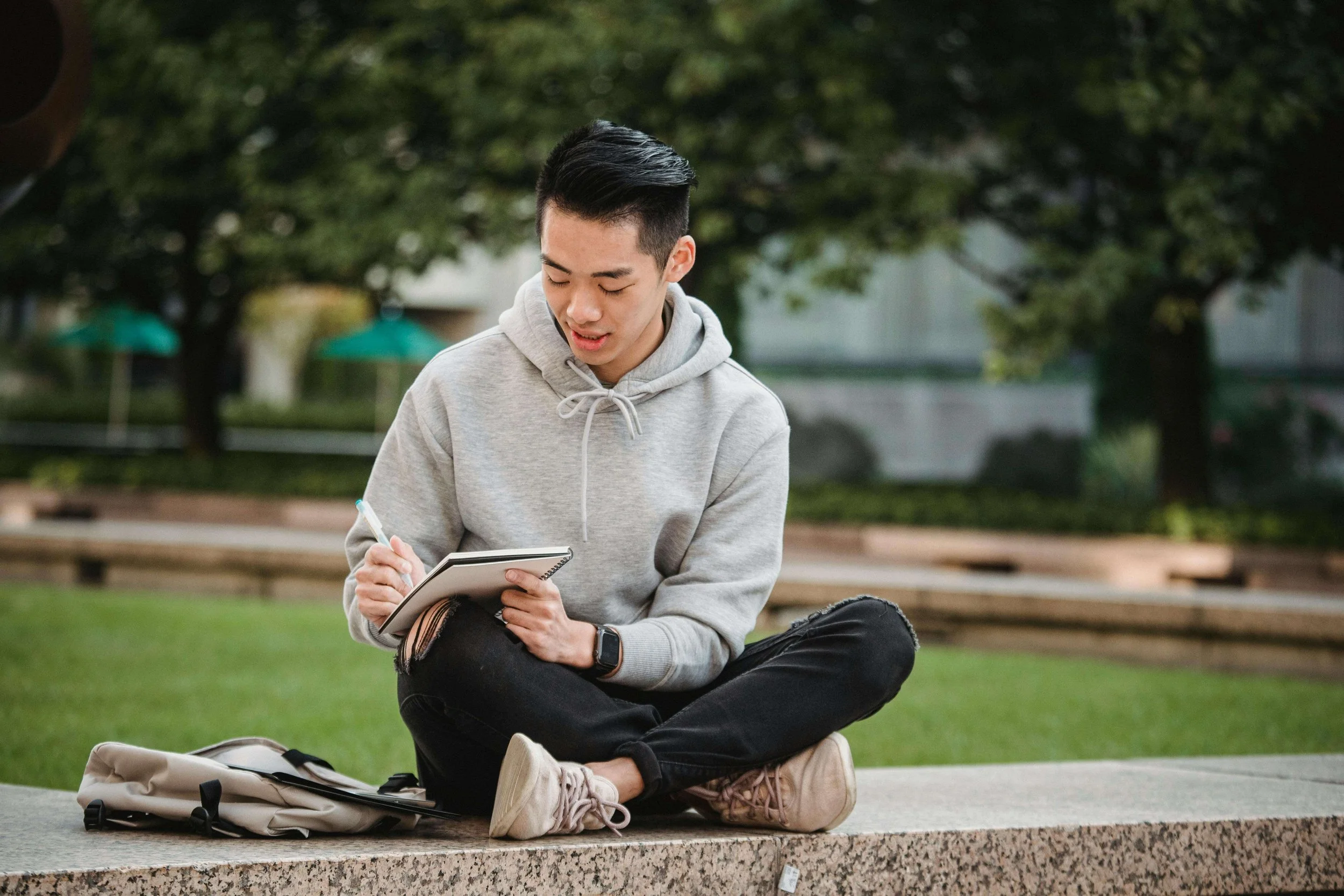 A male student writing in a notebook outside. Do academics and perfection go hand in hand for teenagers? Working with a teen therapist in San Ramon, CA, can guide your child toward realistic goals without pressure.