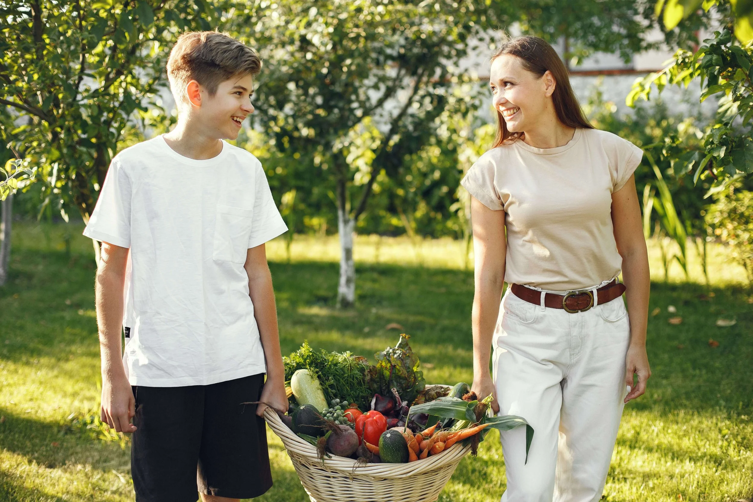 A mother and her teen son laugh together while carrying a basket of fresh vegetables. Does a tiger mom parenting style help or hurt a teen's confidence? Teen therapy in San Ramon, CA can help families explore what truly supports their teen.
