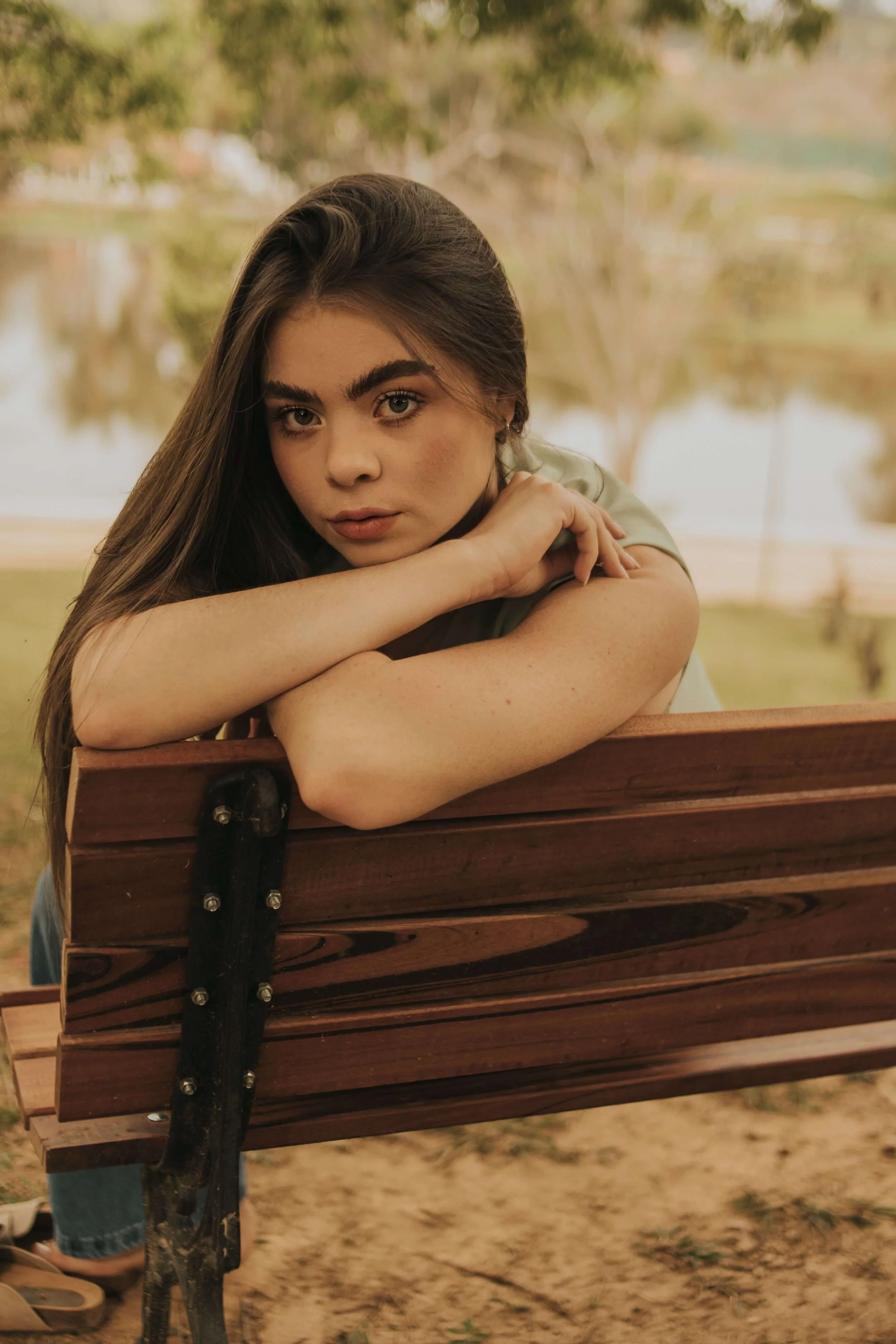 A teen girl leans against a wooden bench, gazing thoughtfully at the camera outdoors. What makes decision making so hard during the teen years? A teen therapist in San Ramon, CA can help identify what's holding your teen back.