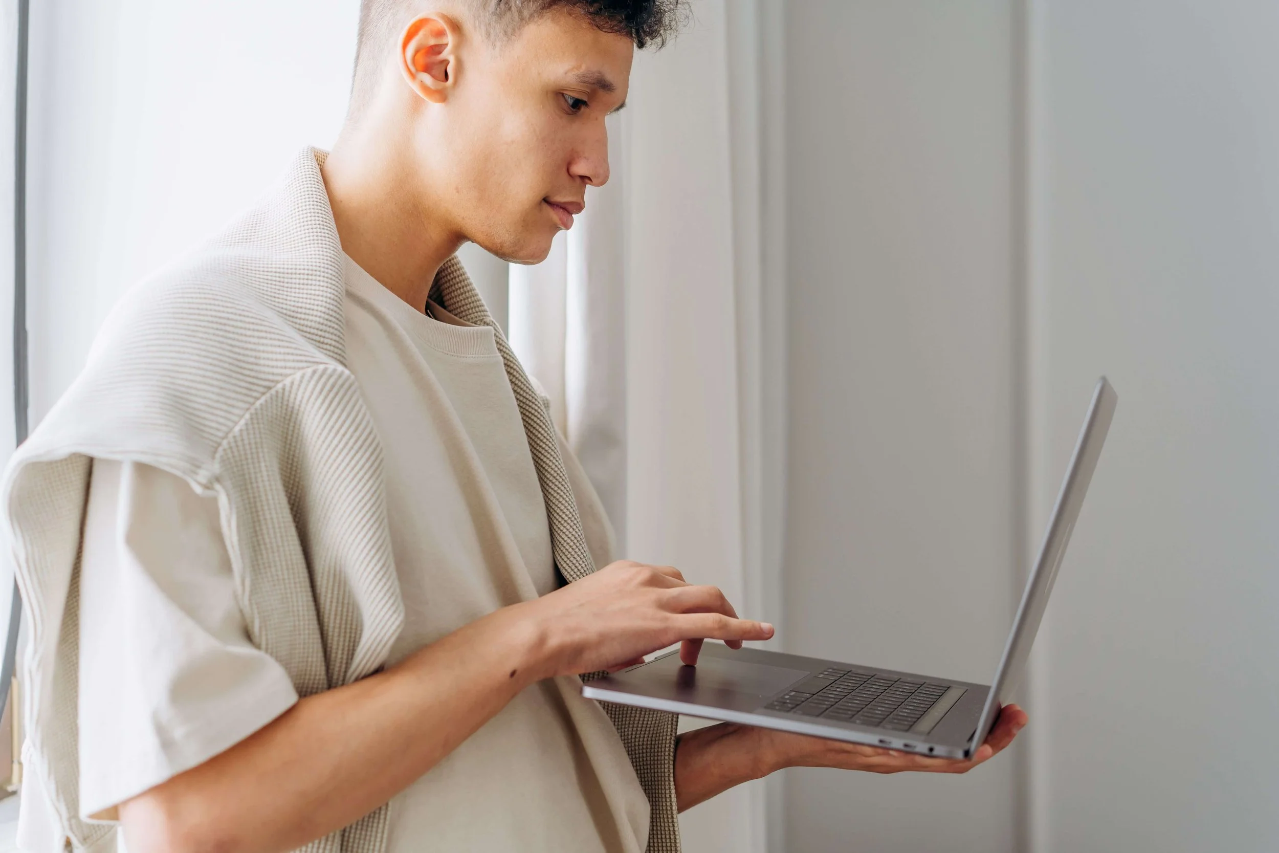 A young man focuses intently while typing on a laptop near a window. Does senior year bring up more complicated emotions than your teen expected? Teen therapy in San Ramon, CA can help them navigate this transition with support.