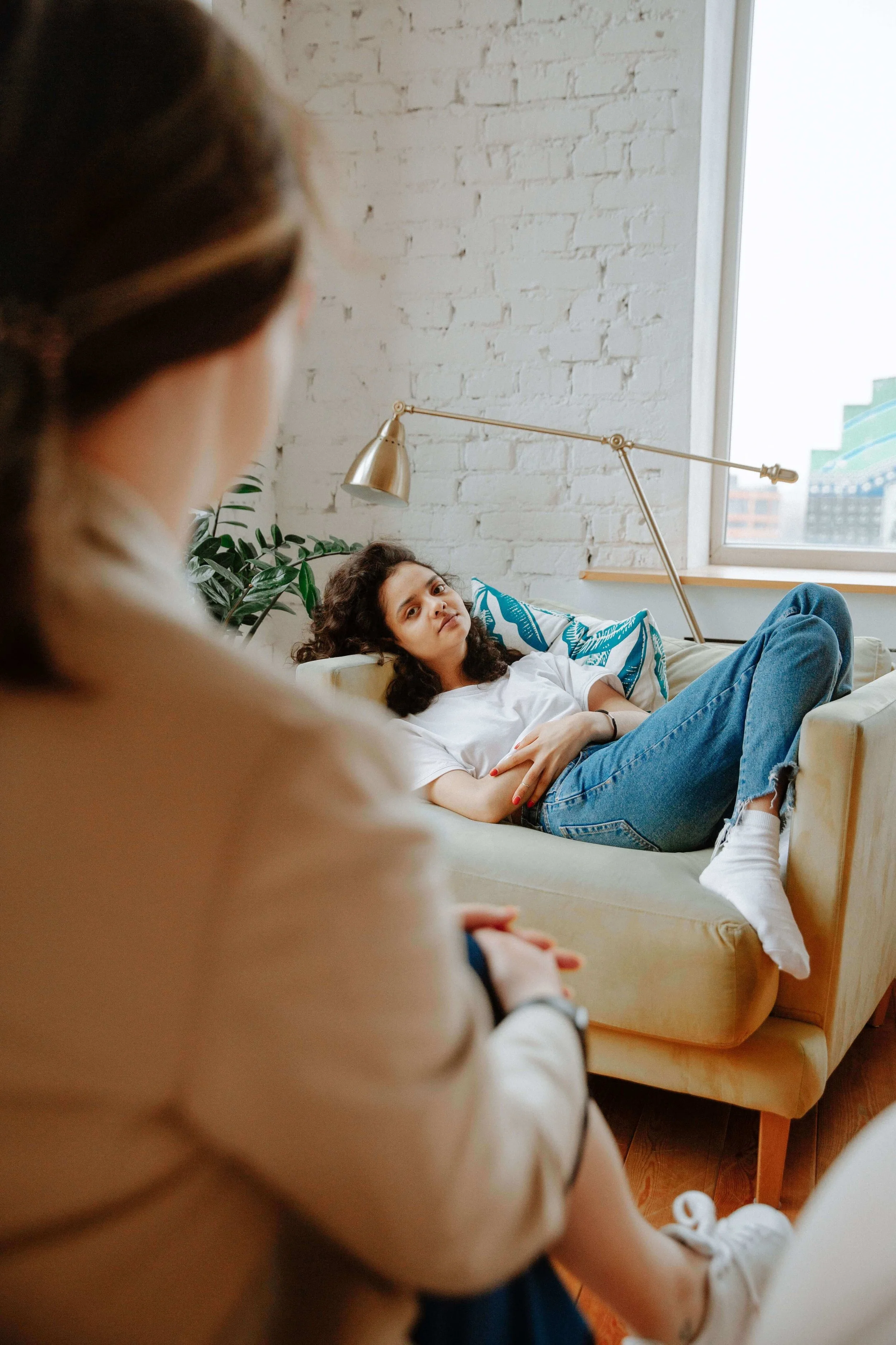 A teen girl reclines on a couch while talking with her therapist. What does teen conflict look like when it starts affecting home life? Teen therapy in San Ramon, CA can give teens a safe space to work through it.