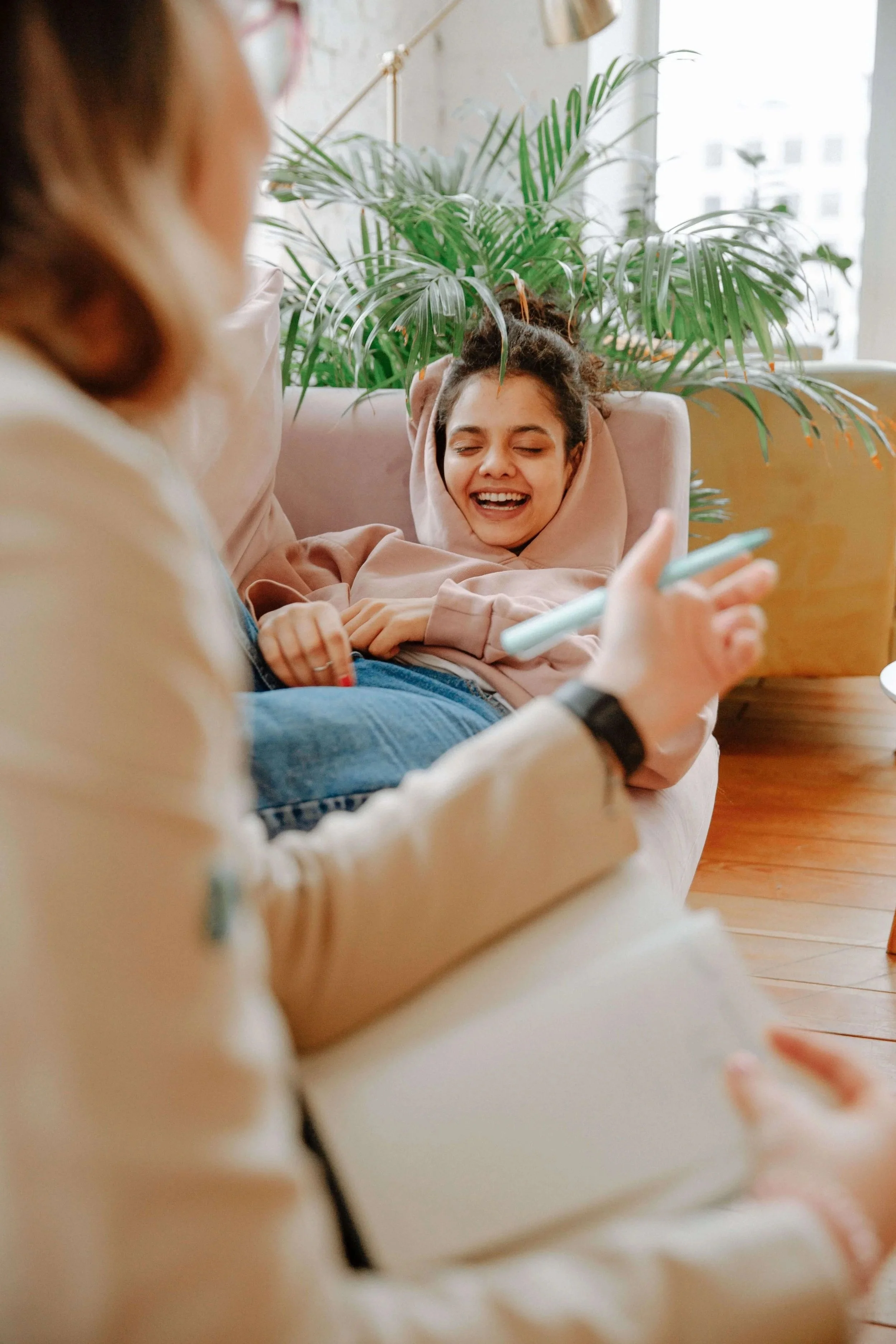 A teen girl smiles while lying on a couch during a therapy session.